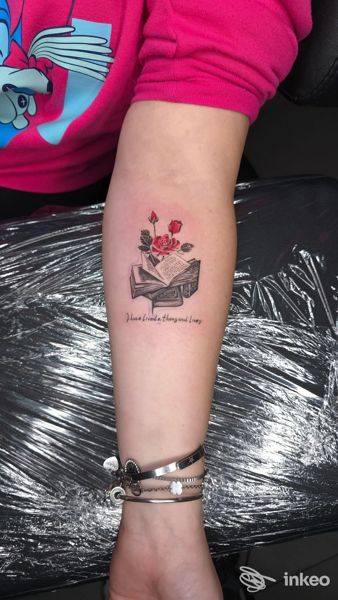 Tatuaggio su avambraccio con libro aperto e rose rosse, foto fornita da Red Skin Tattoostudio a Cavarzere.