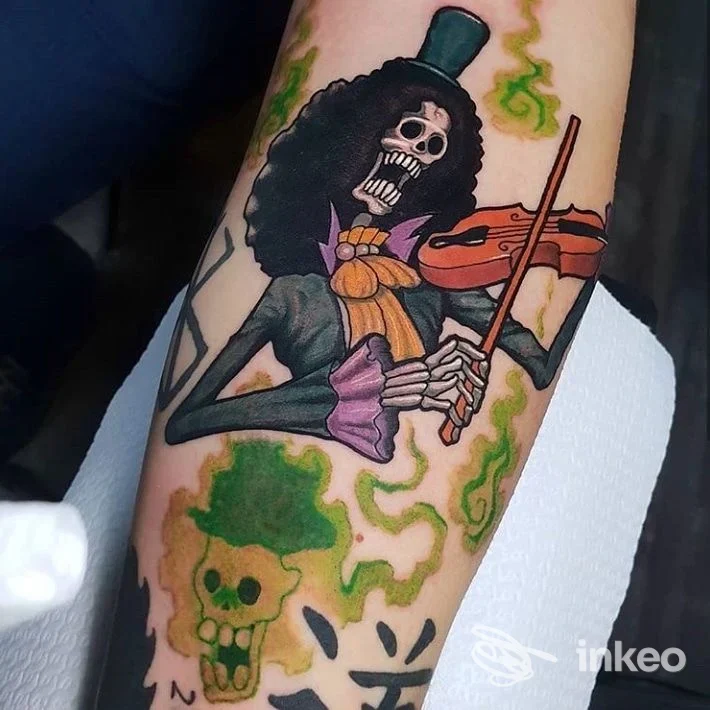 Tatuaggio colorato su avambraccio raffigurante uno scheletro musicista con violino, fotografato al Rename Tattoo Studio a Campi Bisenzio.
