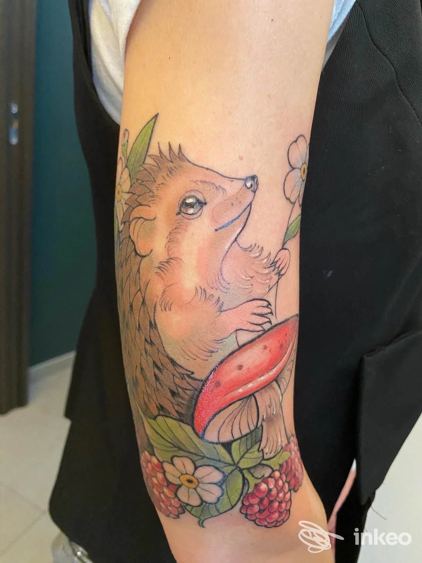 Tatuaggio di un riccio con fungo e fiori sull'avambraccio, realizzato da Supercalifragil Ink Tattoo Shop a Porto Viro.