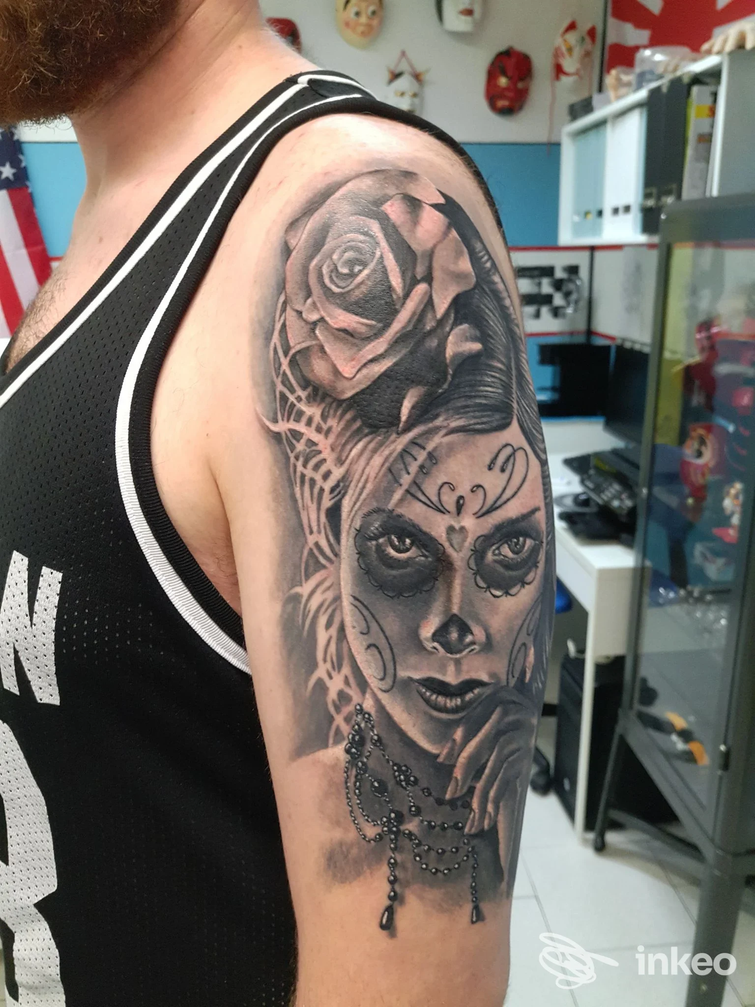 Tatuaggio black and grey raffigurante una sugar skull con rosa sulla spalla, New Skin Tattoo, Copparo.