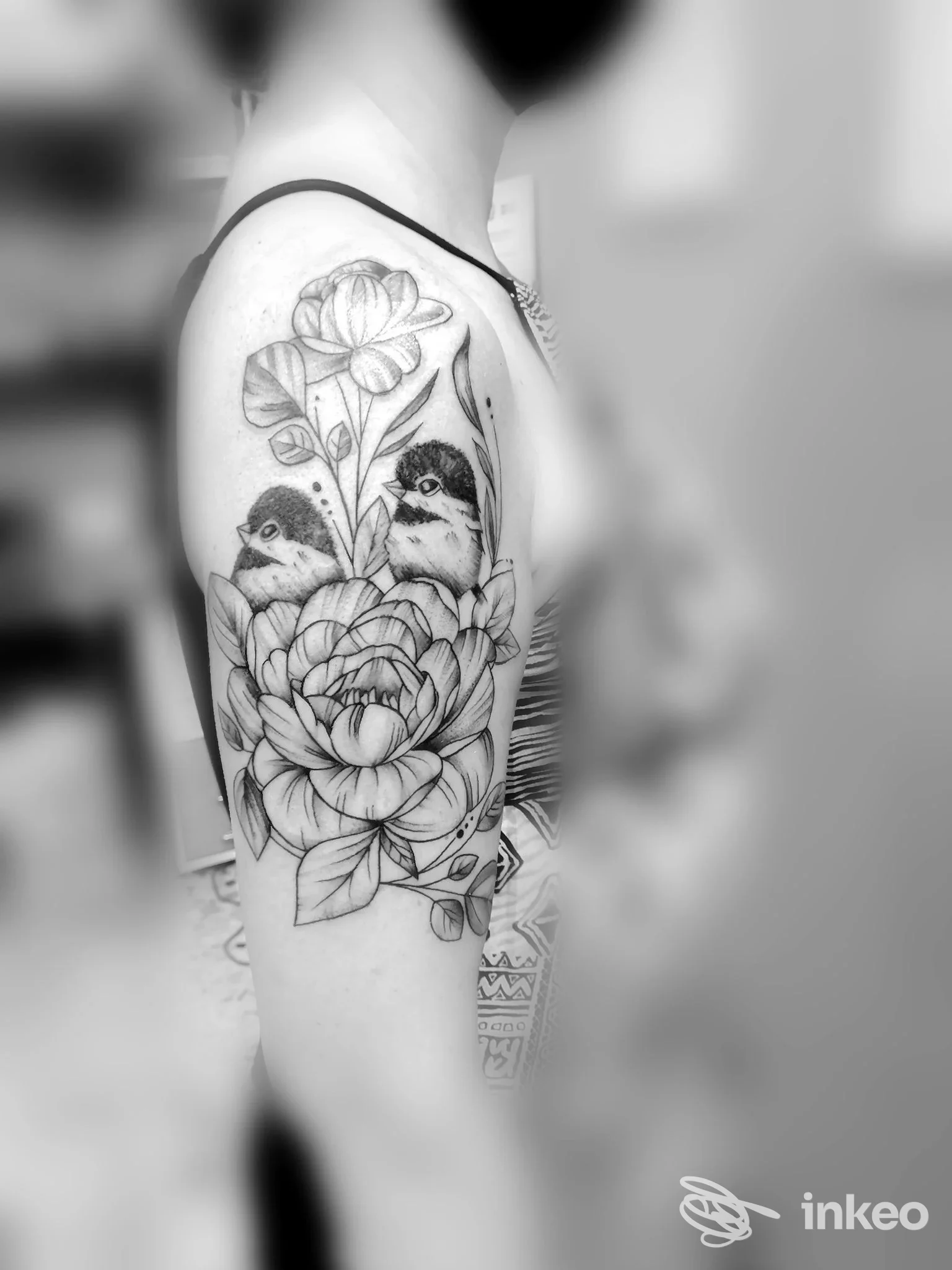 Tatuaggio floreale con due uccellini sul braccio superiore, fotografia fornita da Australian Tattoo a Cuneo.