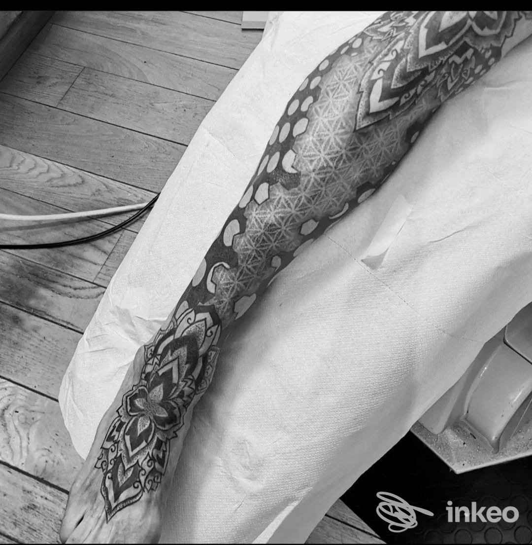Fotografia in bianco e nero di una manica tatuata geometrica che copre avambraccio, polso e dorso della mano, scattata in studio Cippo tattoo a Formigine.