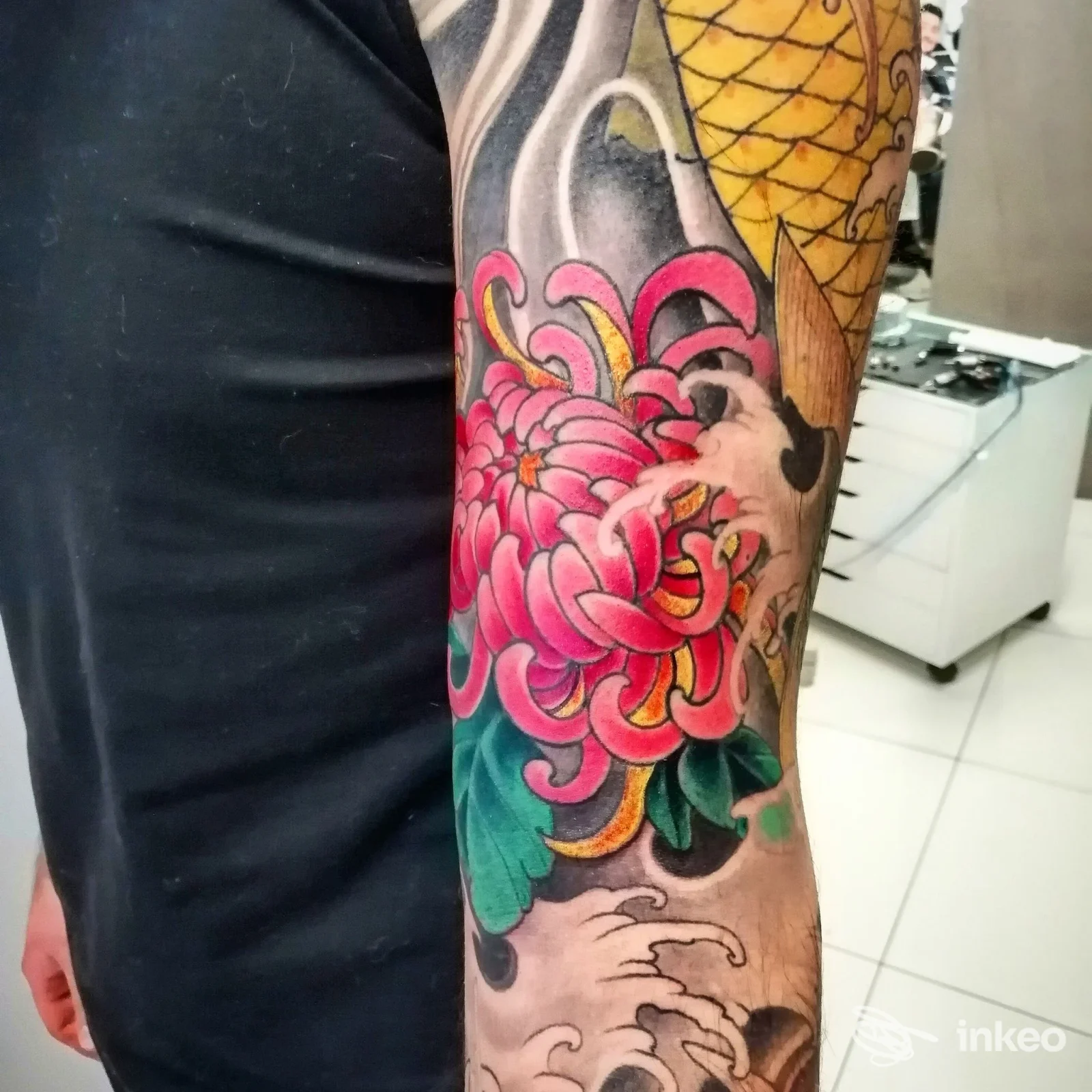Tatuaggio floreale colorato su avambraccio con petali rosa e foglie verdi, Andy Tattoo Rovigo, Rovigo.