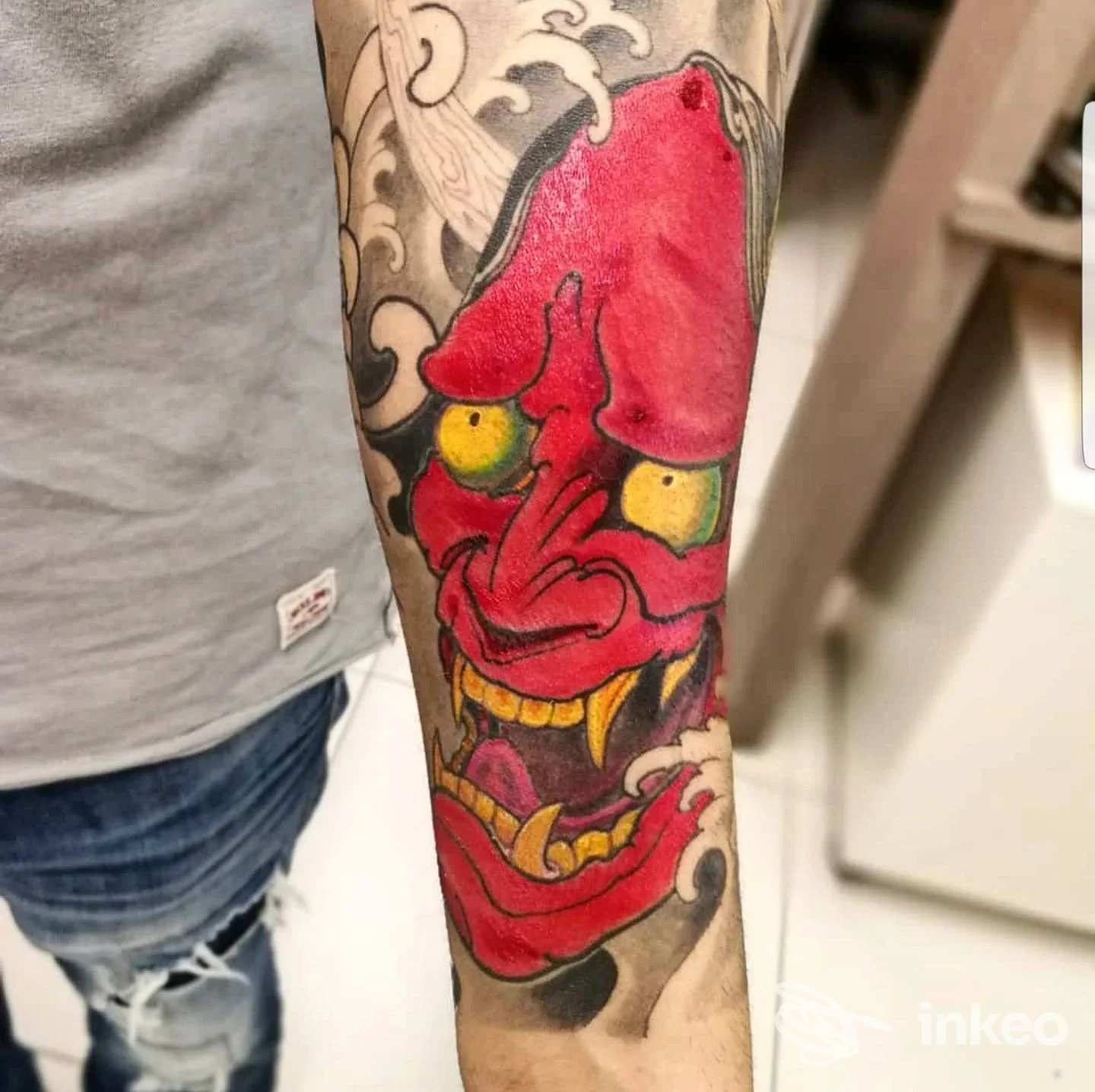Primo piano di tatuaggio a maschera demoniaca rossa sull'avambraccio, foto condivisa da Andy Tattoo Rovigo, Rovigo.