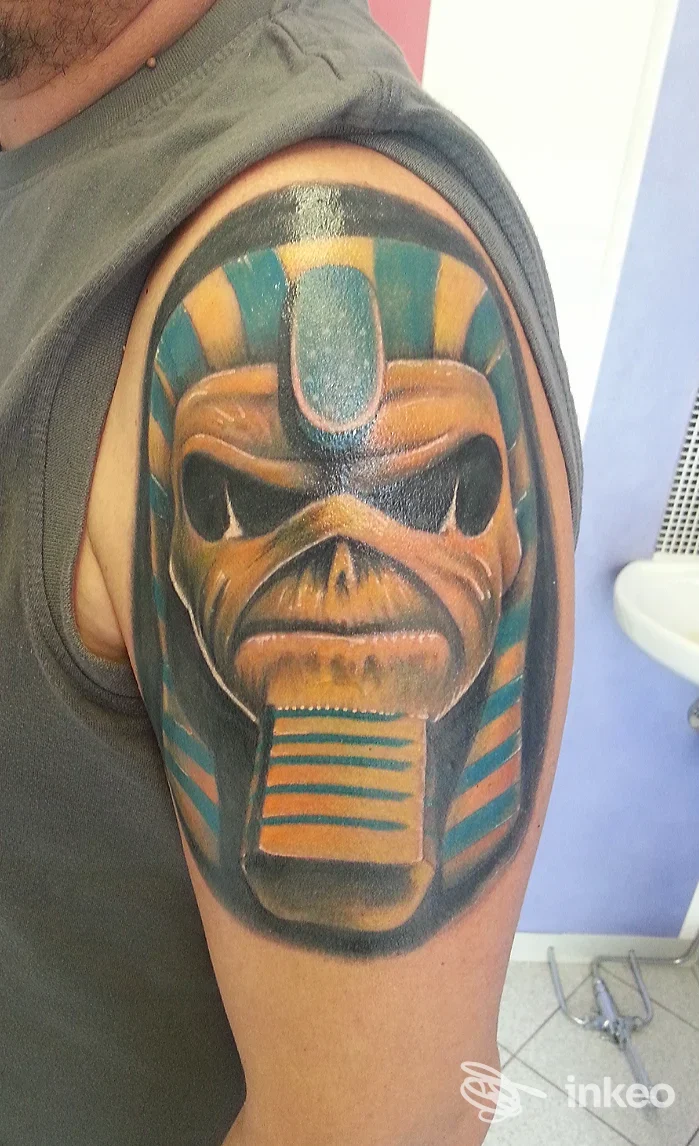 Tatuaggio a tema maschera egizia sul deltoide fotografato allo studio Sts Tattoo a Taglio di Po.