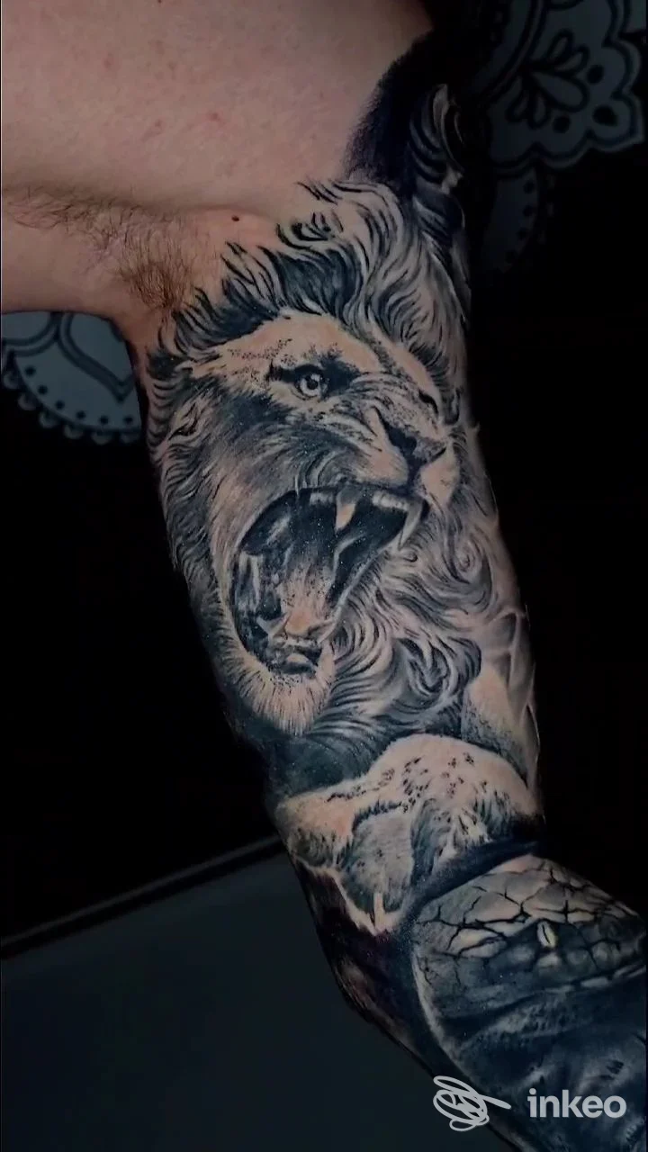 Tatuaggio realistico in bianco e nero con testa di leone ruggente sull'avambraccio, foto fornita da ARI TATTOO PRATO a Montemurlo.