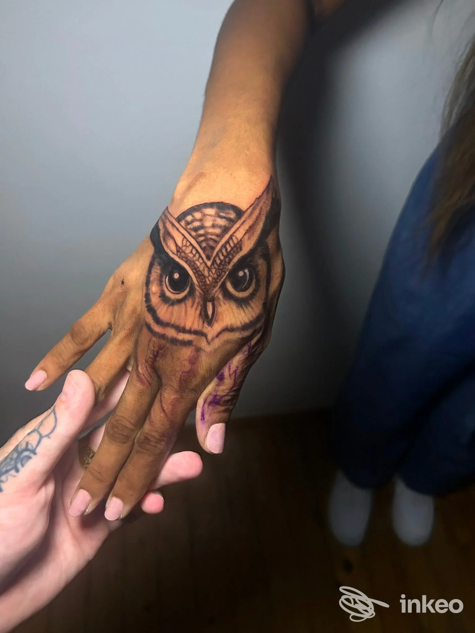 Primo piano di un tatuaggio a forma di civetta sul dorso della mano, foto fornita da Lachiusa Tattoo Club, Casale Monferrato.