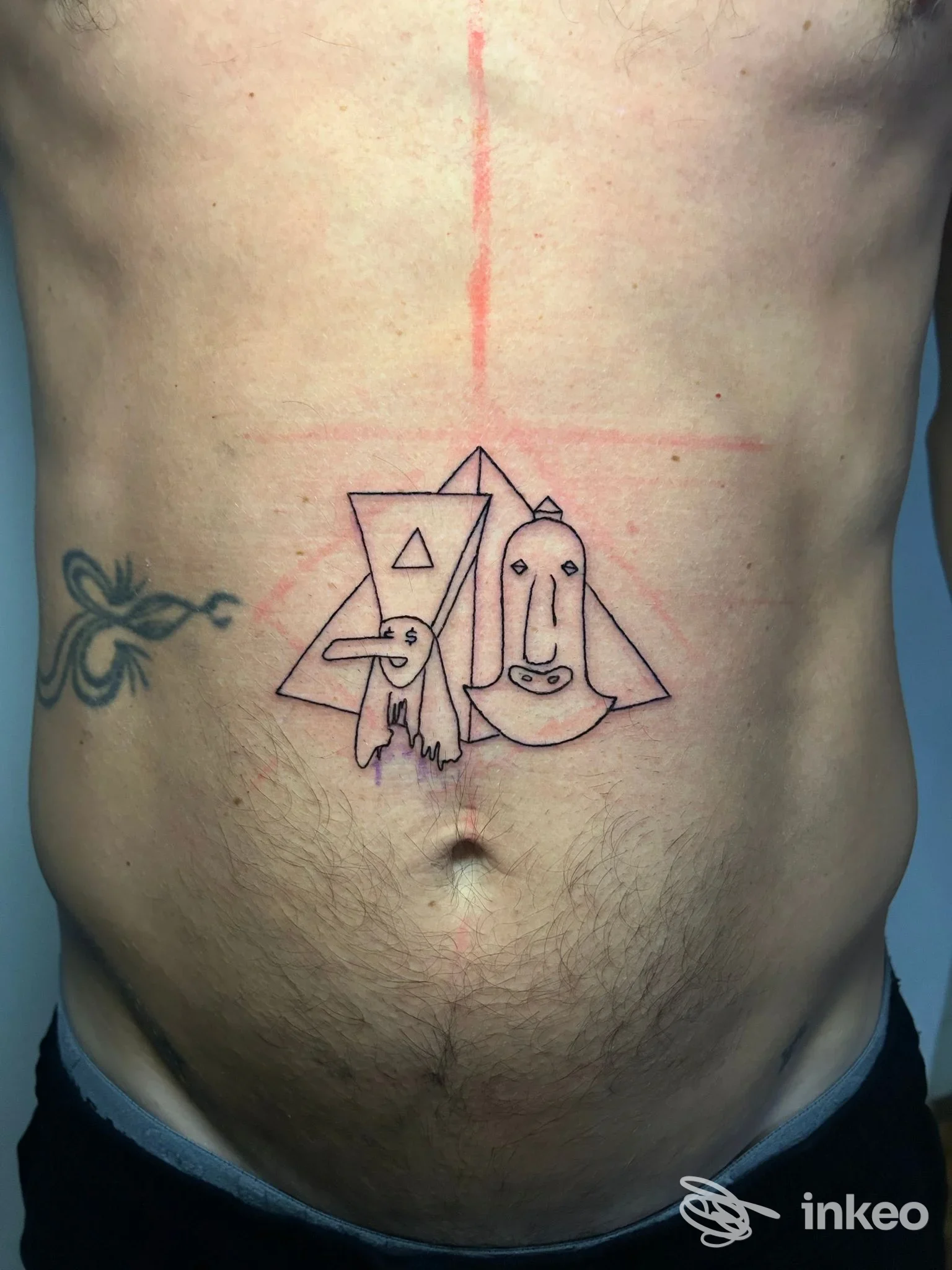 Tatuaggio linework con forme geometriche e volti stilizzati sull'addome, foto di Lachiusa Tattoo Club a Casale Monferrato.