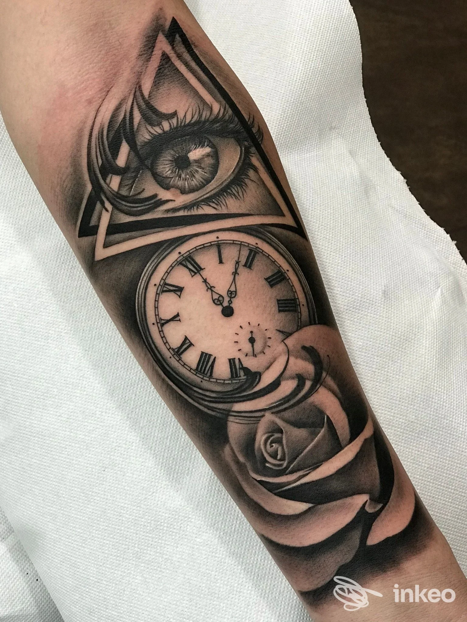 Tatuaggio black & grey su avambraccio con occhio in triangolo, orologio da tasca e rosa – Black Owl Tattoo, Napoli.