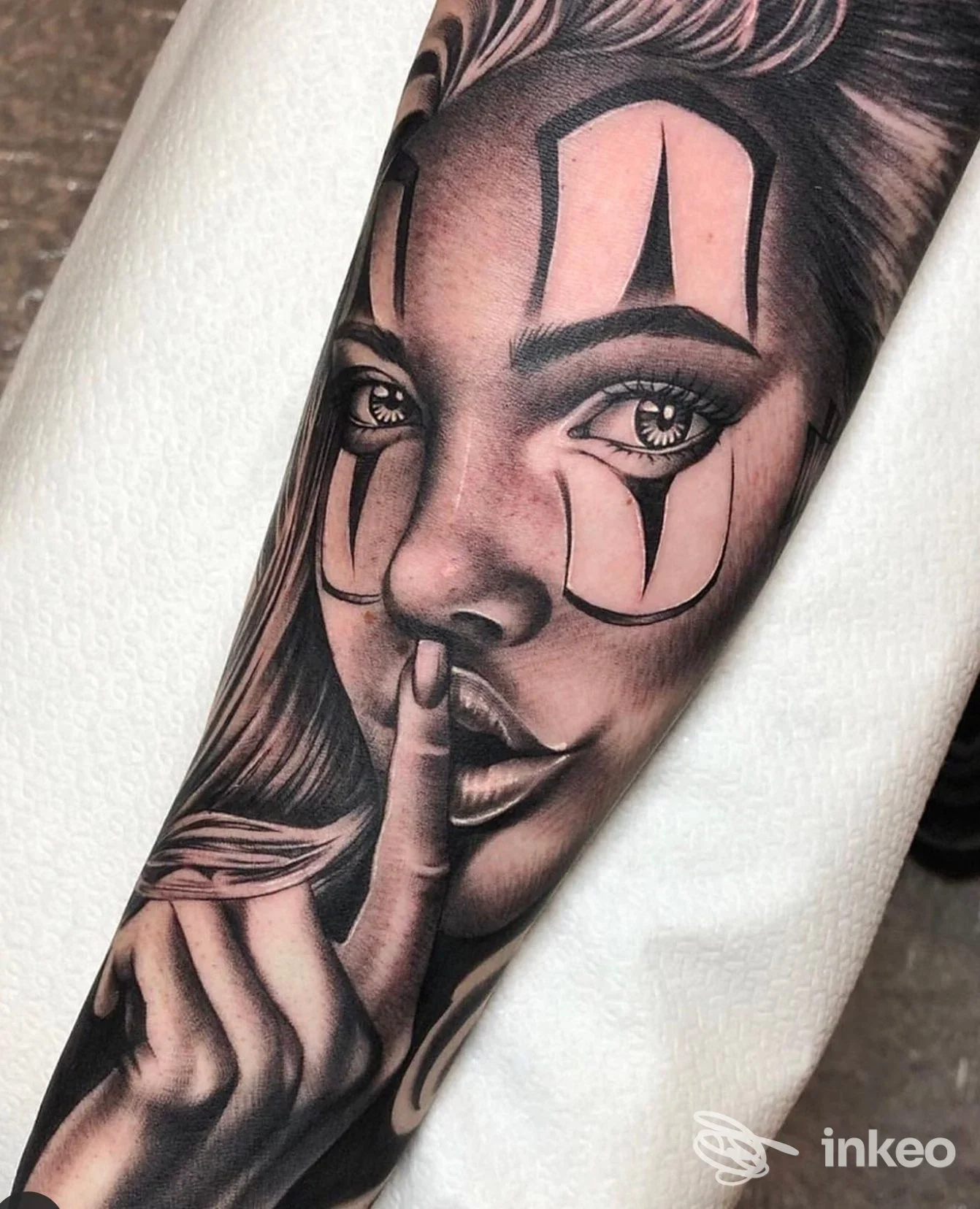 Primo piano di un tatuaggio realistico su avambraccio con volto femminile e mano in posa, eseguito da Mushroom ink a Prato.