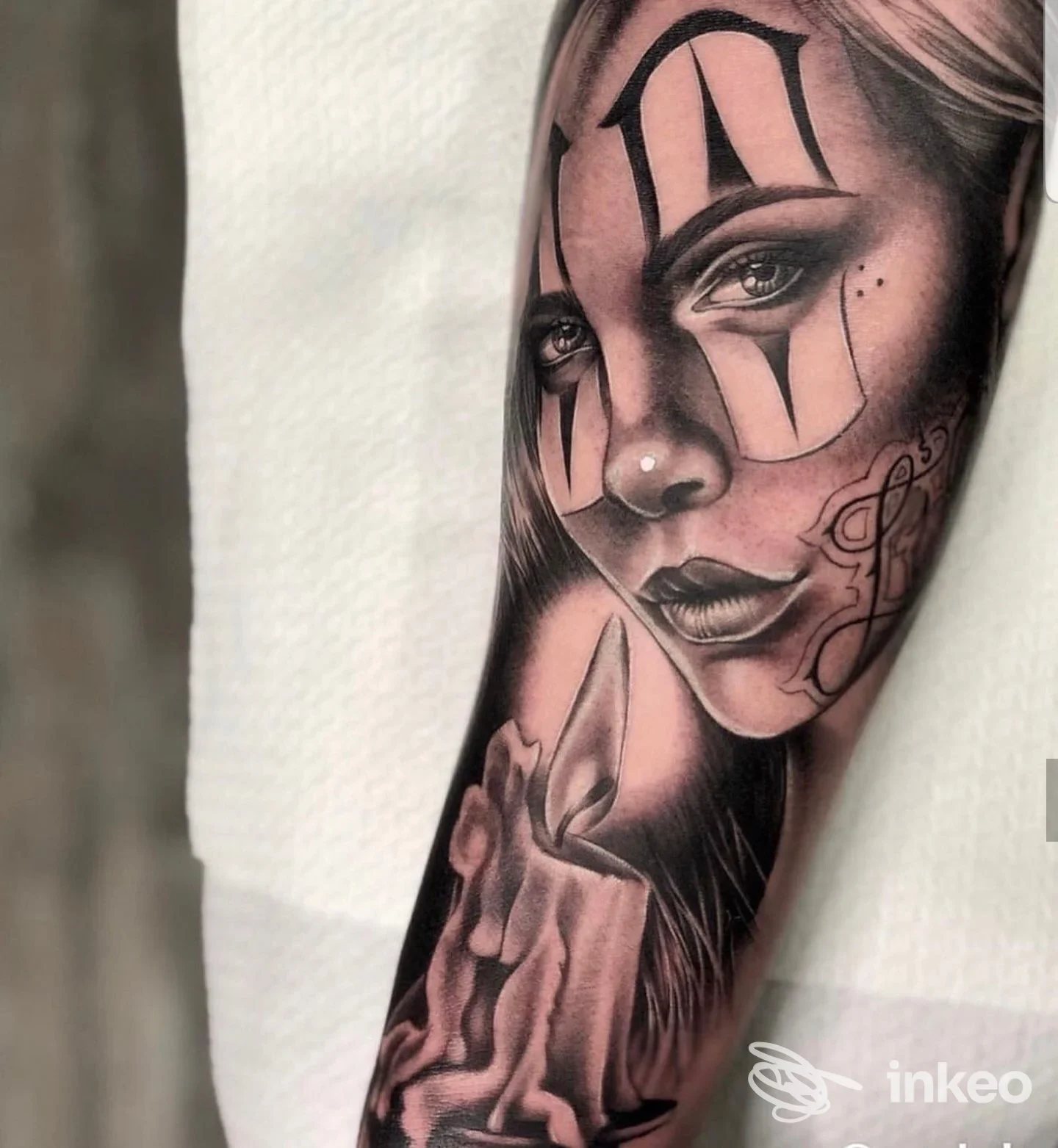 Tatuaggio realistico in bianco e nero su avambraccio, ritratto femminile con candele — Mushroom ink, Prato.