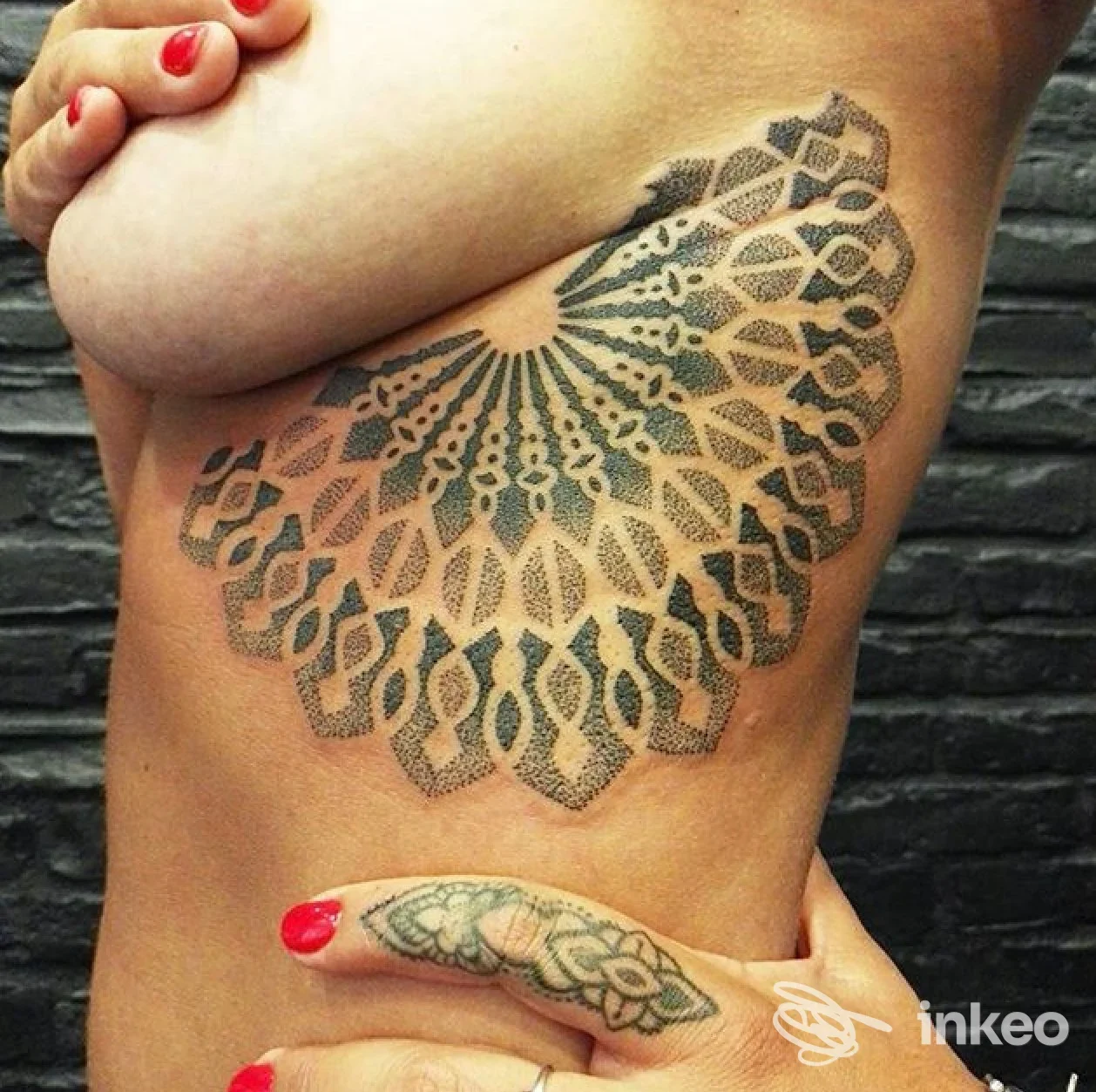 Grande tatuaggio ornamentale a mandala sul fianco sotto il seno, foto fornita da ADRENALINE STUDIO Tattoo & Piercing a Follonica.