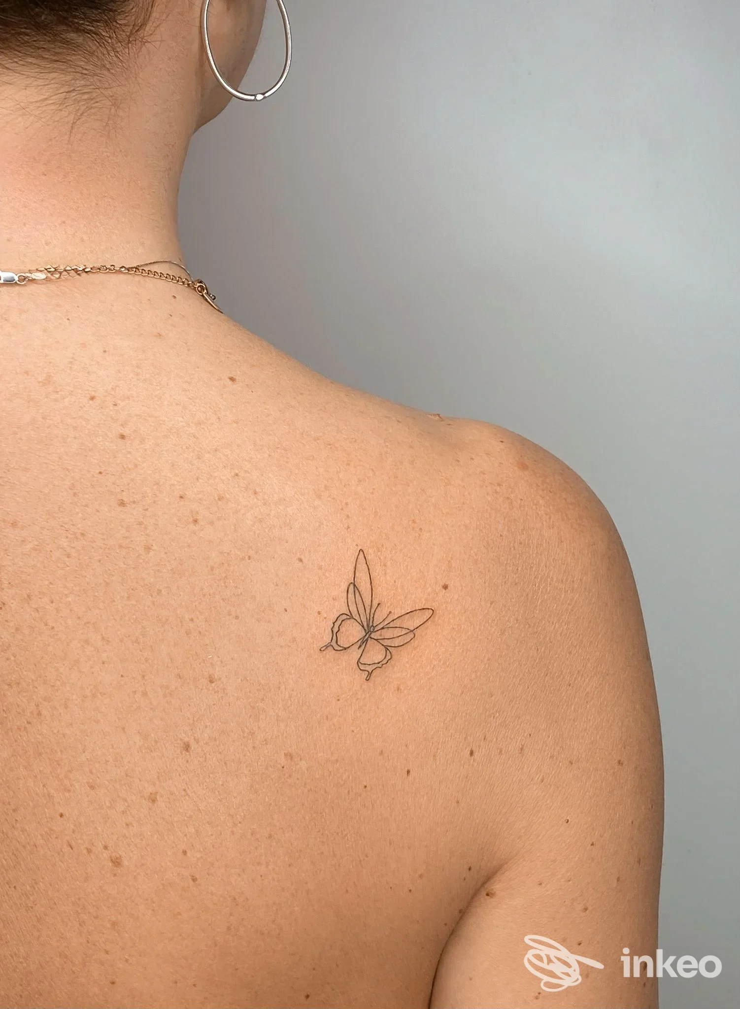 Piccolo tatuaggio a farfalla in linework sulla parte superiore della schiena, foto dello studio Il trucco di Roby a Valenza.