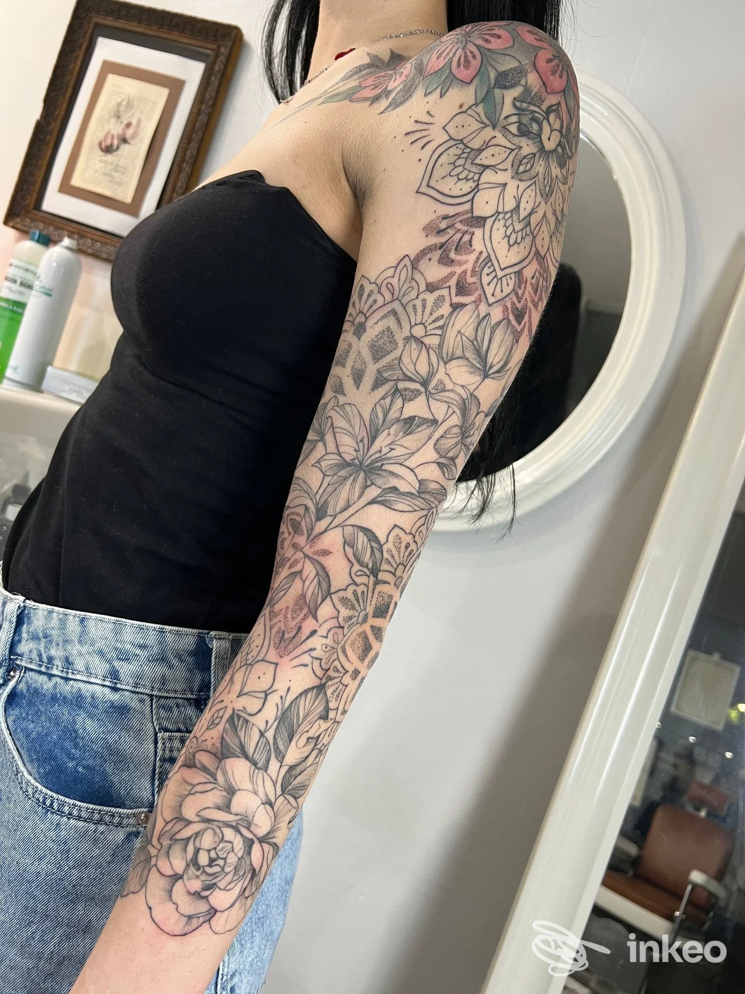Tatuaggio a manicotto floreale visibile sul braccio sinistro, foto dallo studio Emily's Ink di ValentinaEmily Pezzoli a Calenzano.