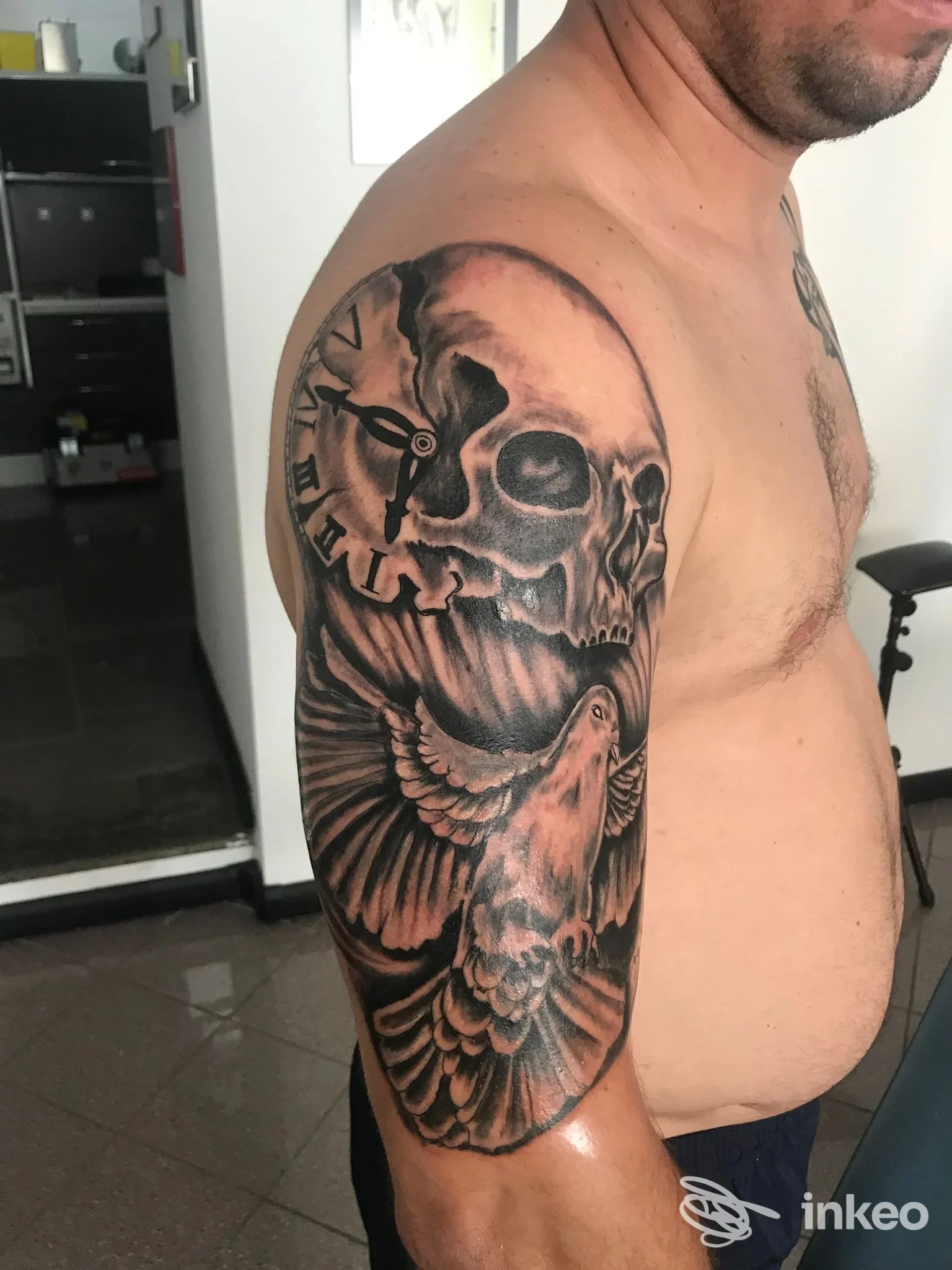 Tatuaggio a mezza manica in bianco e nero con teschio e colomba sul braccio destro, foto fornita da Ink'n'Blood Tattoo di Molea Stefano, Forlì.