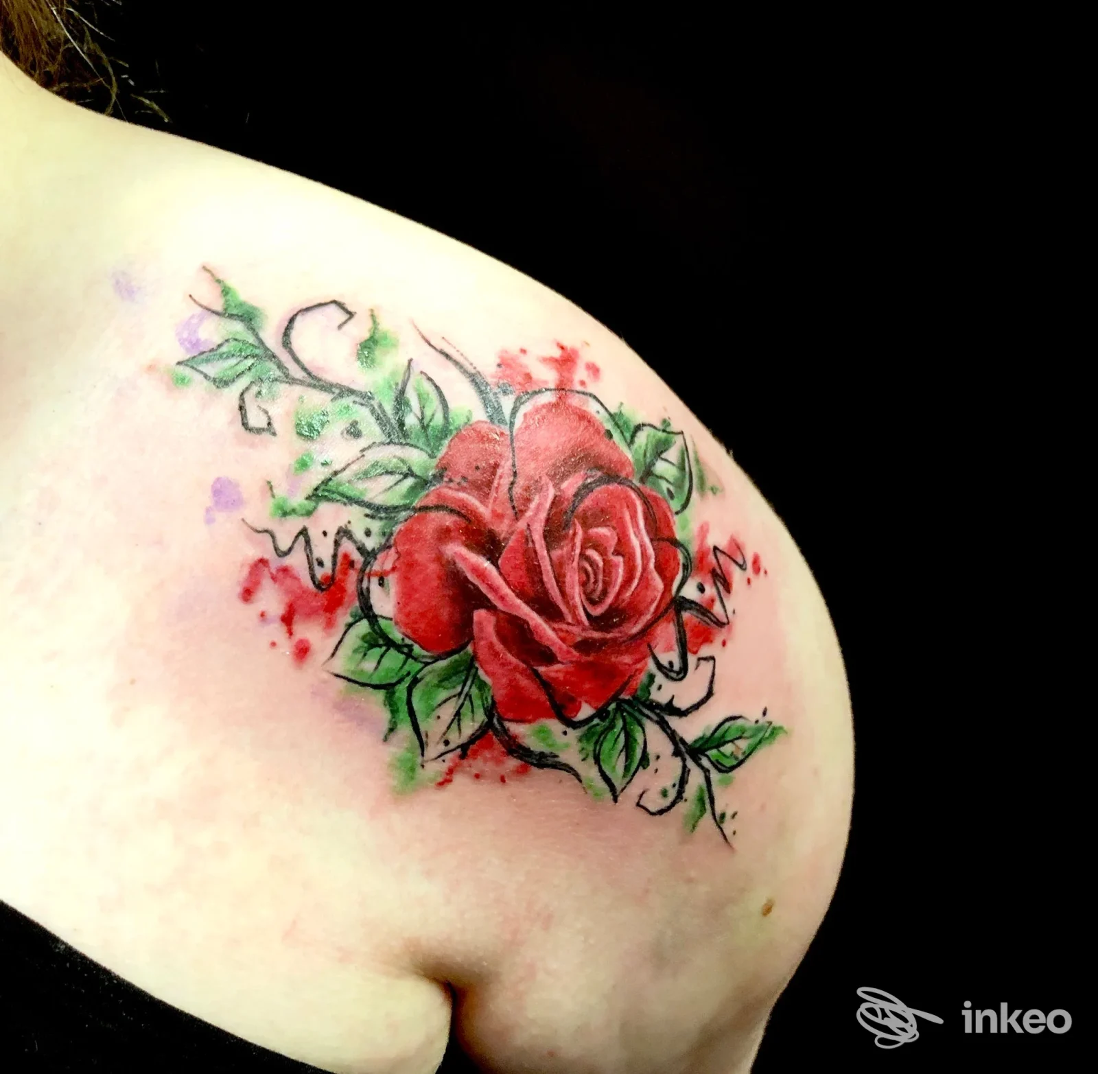 Tatuaggio a rosa rossa con foglie verdi sulla spalla, Il Giglio Nero Tattoo, Campi Bisenzio.