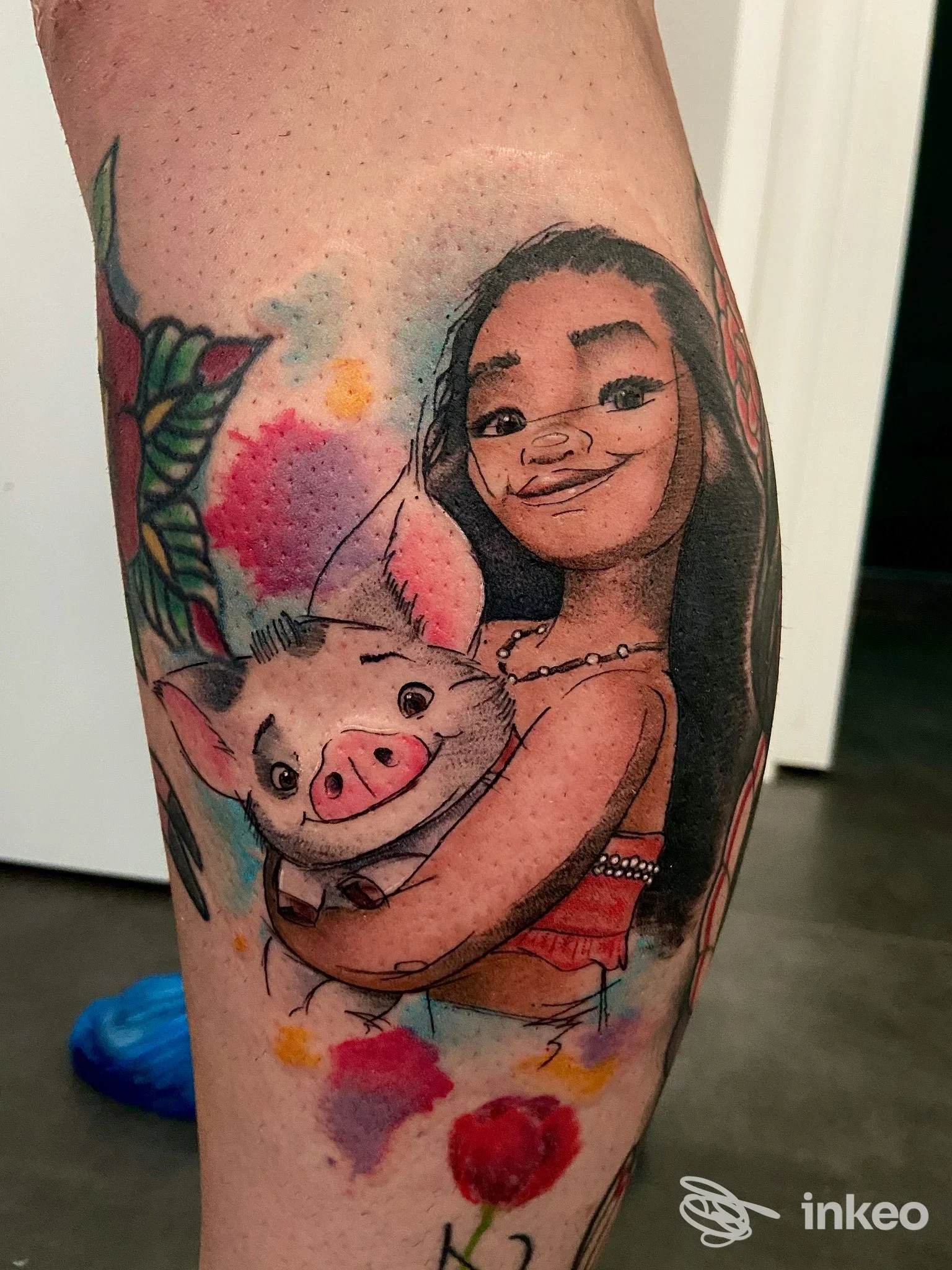 Tatuaggio colorato su polpaccio con figura femminile stilizzata che abbraccia un maialino, Morrygan Tattoo Studio, Ferrara.