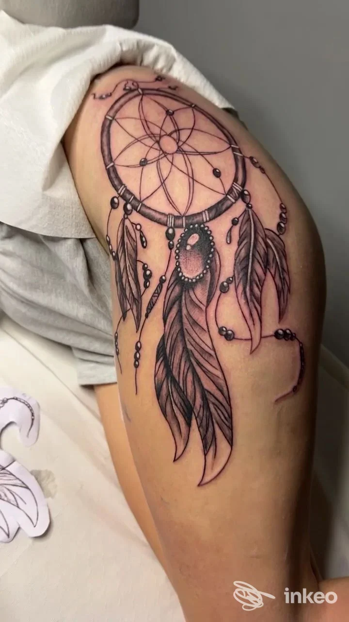 Tatuaggio dreamcatcher sul braccio/spalla realizzato da GiòTattoos a Formia, dettaglio delle piume e linework.