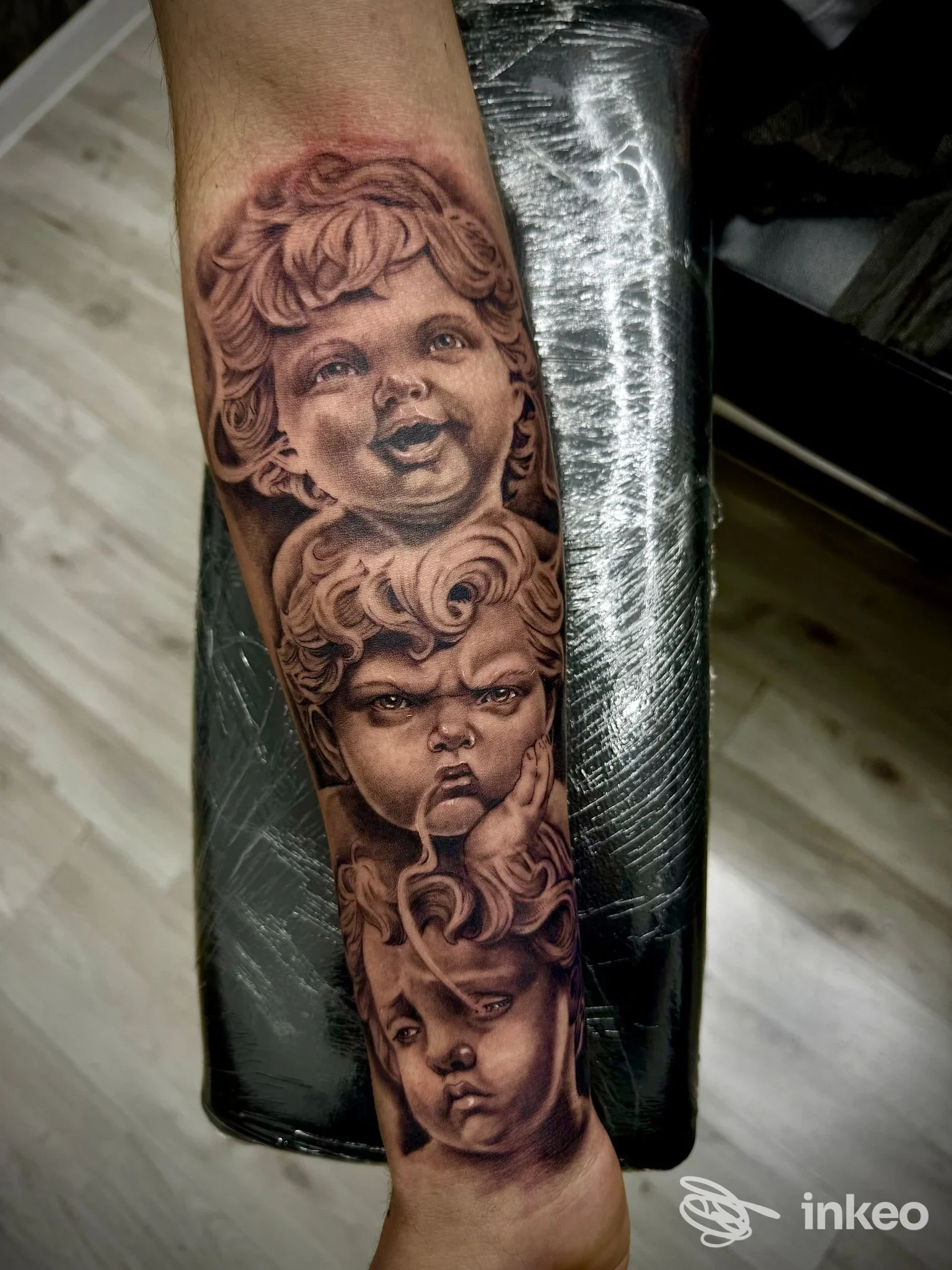 Tatuaggio realistico su avambraccio con tre volti in stile ritratto, Black Art Tattoo Studio, Guidonia Montecelio.