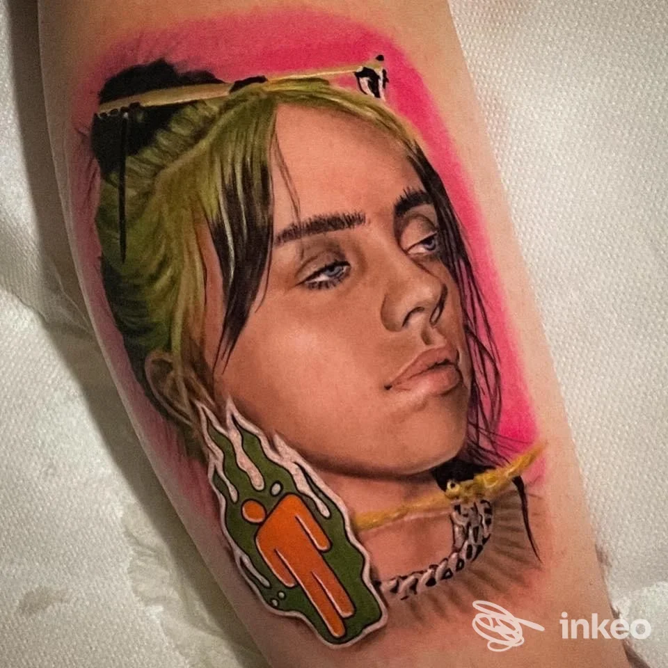 Tattoo realistico su pelle del braccio raffigurante una donna con capelli verdi e sfondo rosa, con un adesivo arancione vicino al collo.