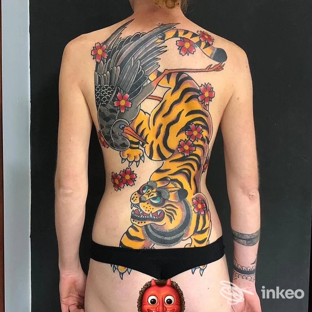 Ampia realizzazione tatuata sul dorso con una tigre e un corvo, colori vividi; immagine fornita da Mystic thorn tattoo, Novi Ligure.