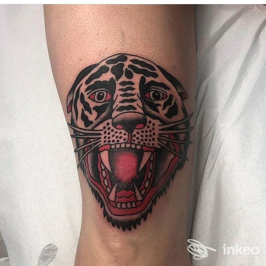 Tatuaggio di testa di felino stilizzata in nero e rosso sull'avambraccio, lavoro dello studio Mystic Thorn Tattoo, Novi Ligure.