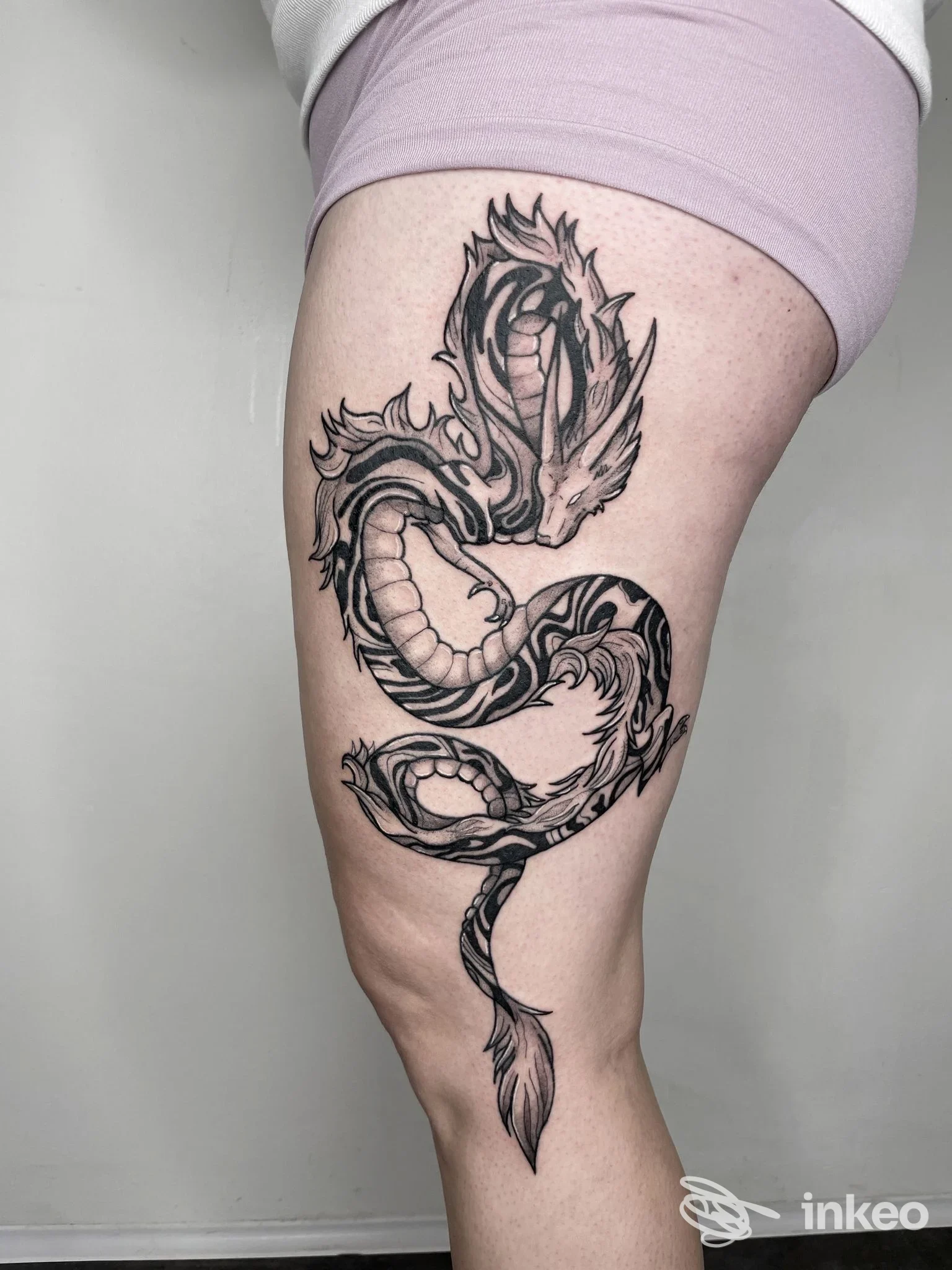 Tatuaggio nero-grigio a motivo serpentino sulla coscia, foto fornita dallo studio Marblueyes Tattoo di Cuneo.