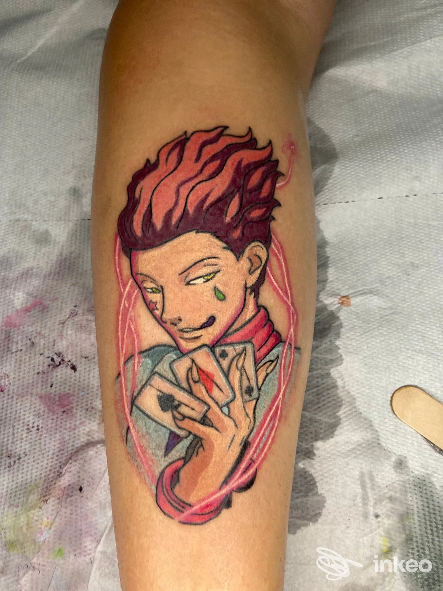 Tatuaggio colorato su avambraccio raffigurante un personaggio con carte da gioco, realizzato da Santoryu Ink a Rapallo.