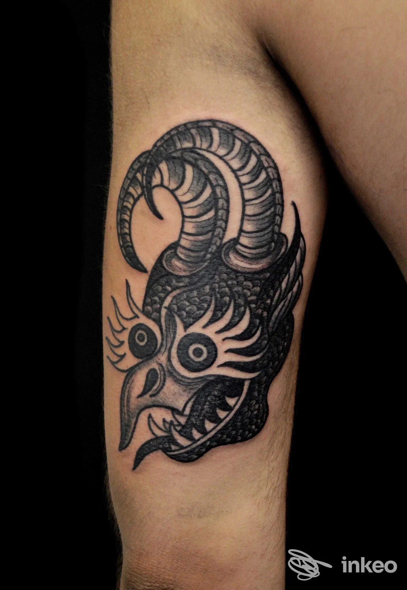 Tatuaggio blackwork raffigurante una testa cornuta sul braccio superiore interno, realizzato da Pollution Tattoo a San Cesareo.