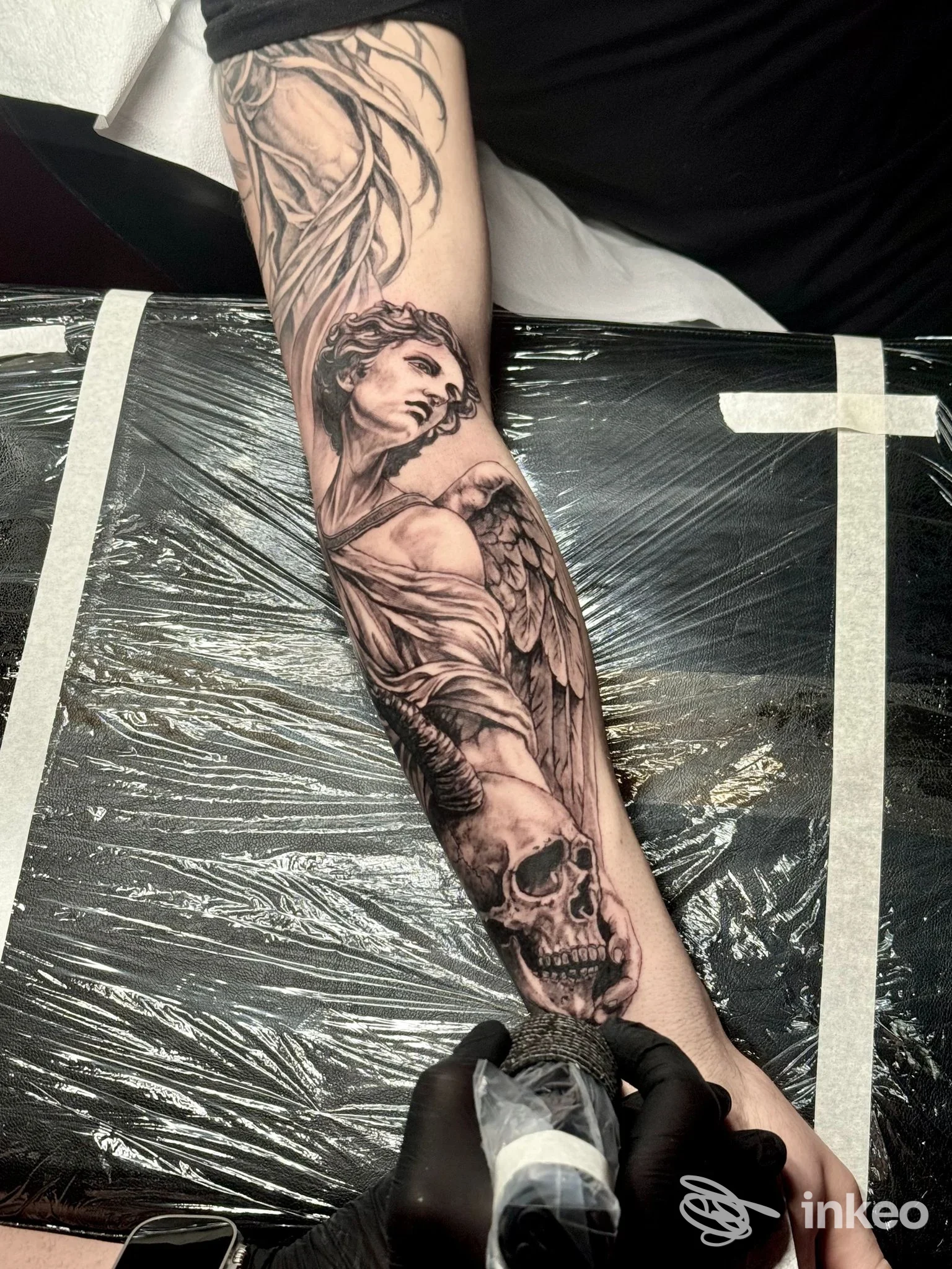 Tatuaggio realistico a Torino presso Ink Gallery Studio: angelo e teschio su avambraccio in fase di lavorazione.
