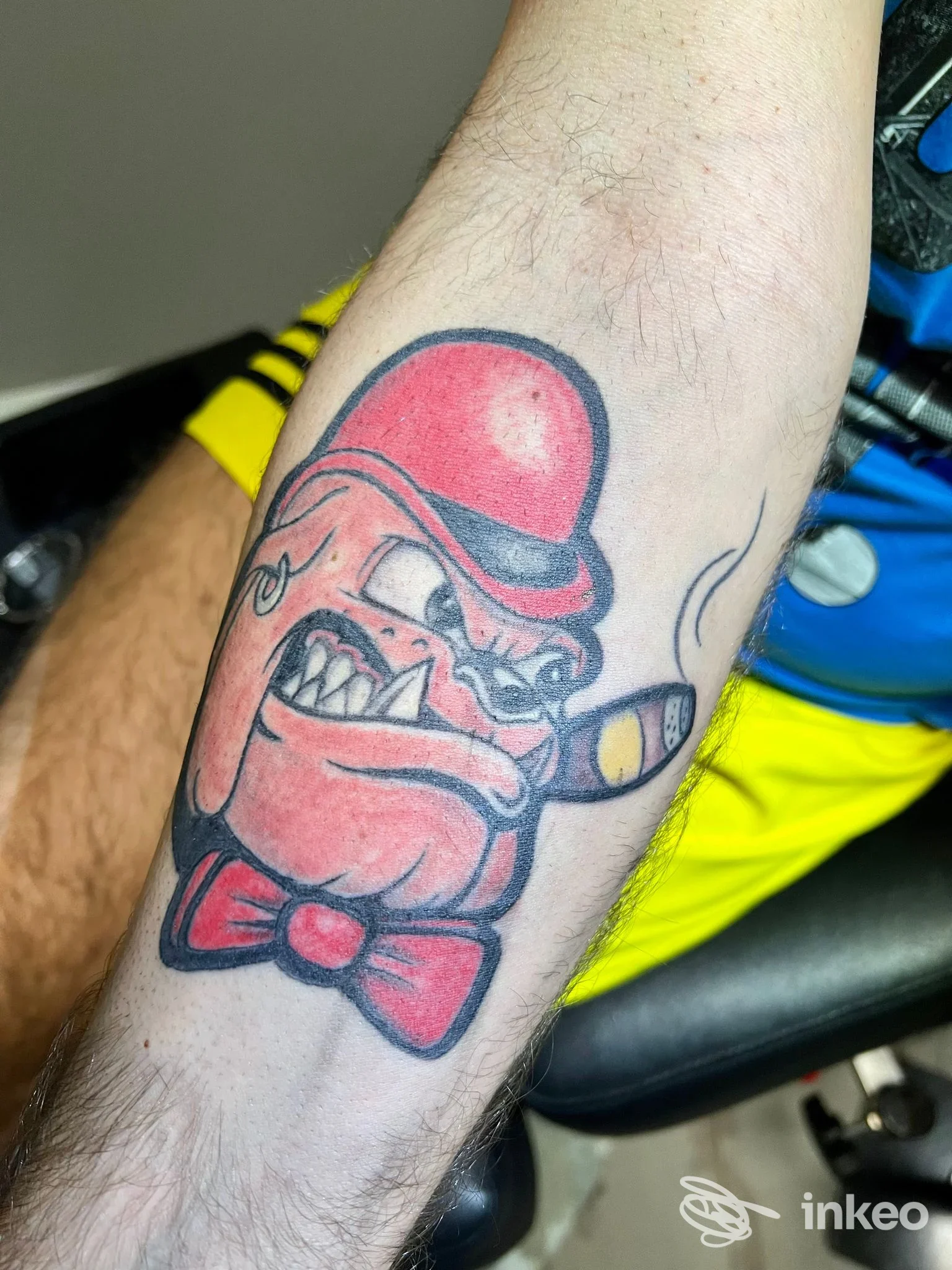 Tatuaggio su avambraccio con personaggio cartoon con bombetta rossa e sigaro, Frog Ink Tattoo, Riccione
