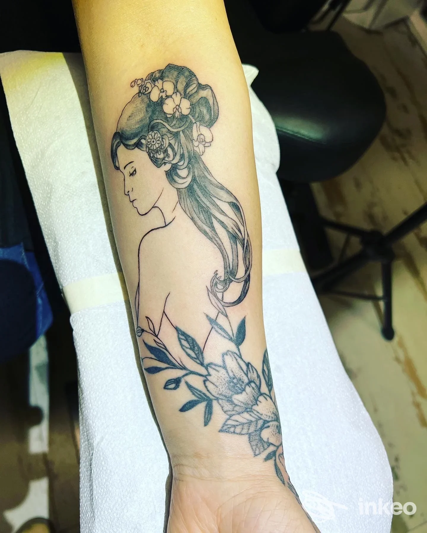 Tatuaggio in nero di profilo femminile e fiori sull'avambraccio, foto per Frog Ink Tattoo a Riccione.