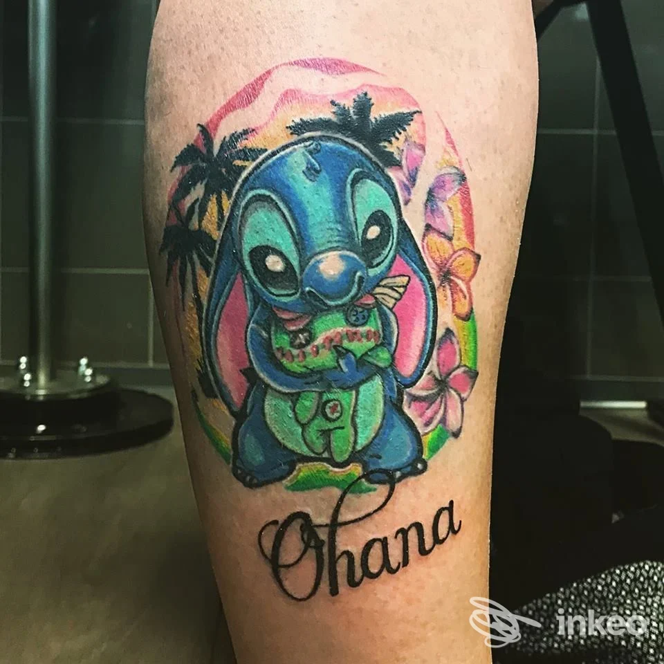 Tatuaggio colorato di Stitch con fiori sul polpaccio, Studio Xina Tattoo Mani d’oro, Roma.