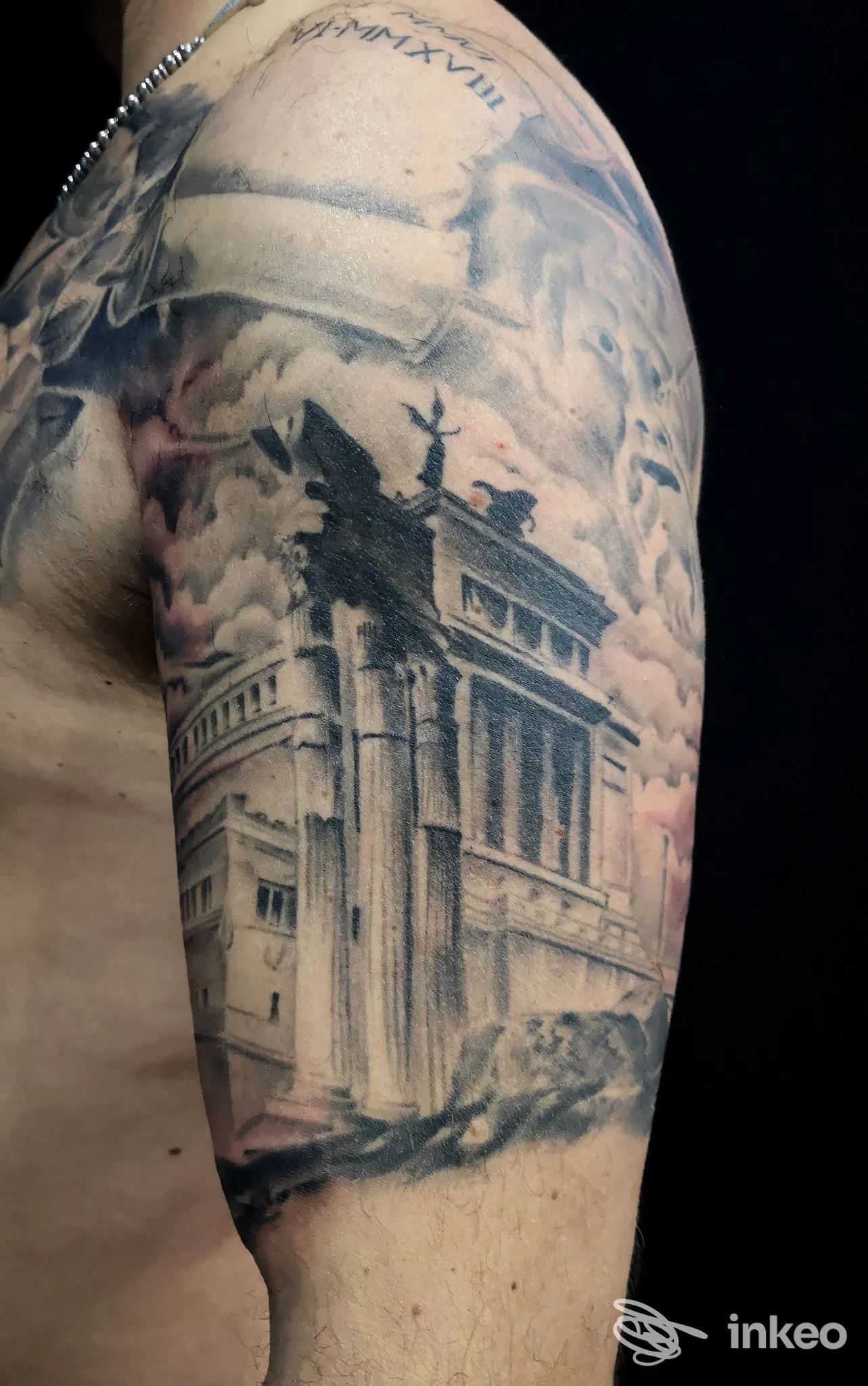 Tatuaggio realistico a tema architettonico sull'omero di un cliente, fotografia fornita da Hack Zone Tattoo Studio, Roma.