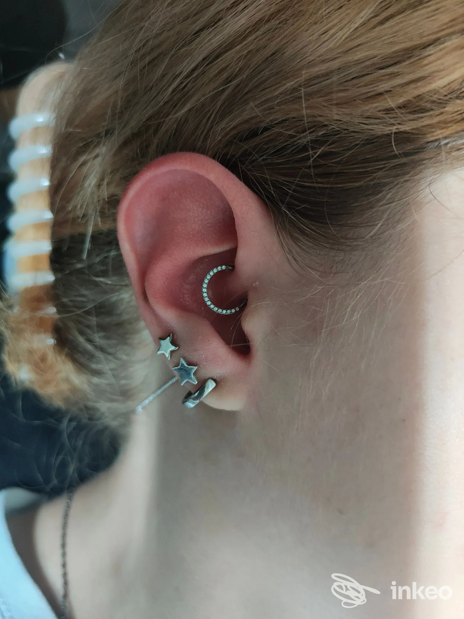 Dettaglio dell'orecchio con più piercing e gioielli in argento, foto per Underskin Needle & Ink Studio, Viterbo.