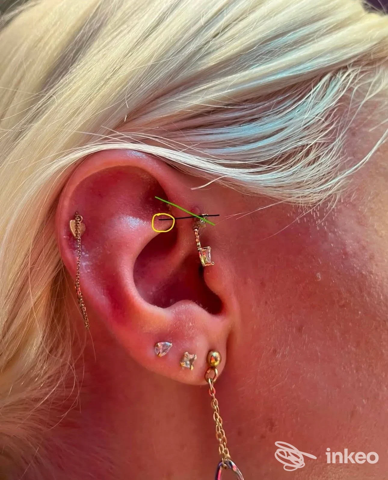 Primo piano di un orecchio con più piercing e catenella, foto fornita da Darkside Piercing Gioielli, Roma.