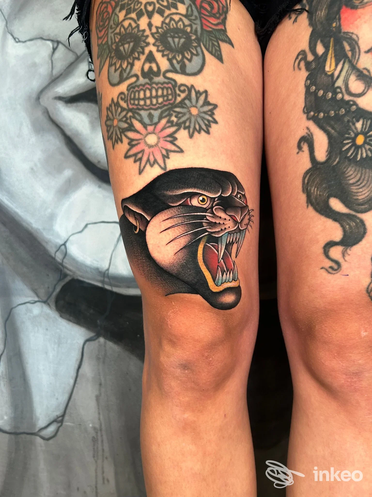 Tatuaggi sul ginocchio e sulla coscia con testa di pantera e motivi floreali, foto da Officina 72 Tattoo Studio, Viterbo.