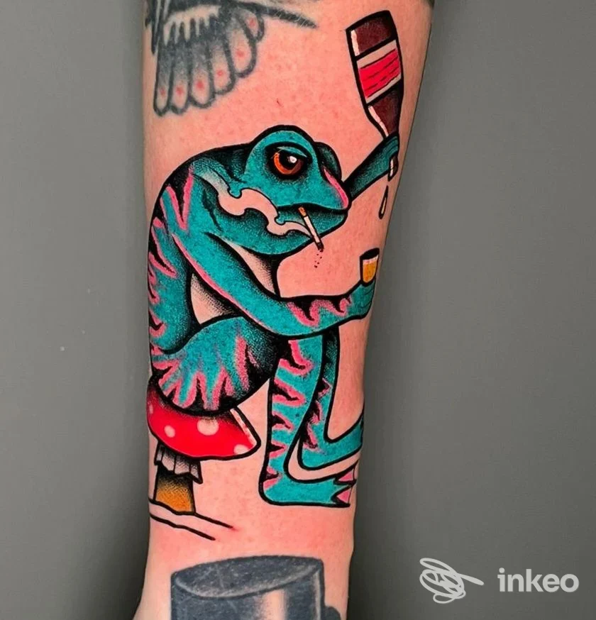 Tatuaggio colorato di una rana che tiene un bicchiere sull'avambraccio, inviato da Bright and Bold Tattoo Studio, Tortona.