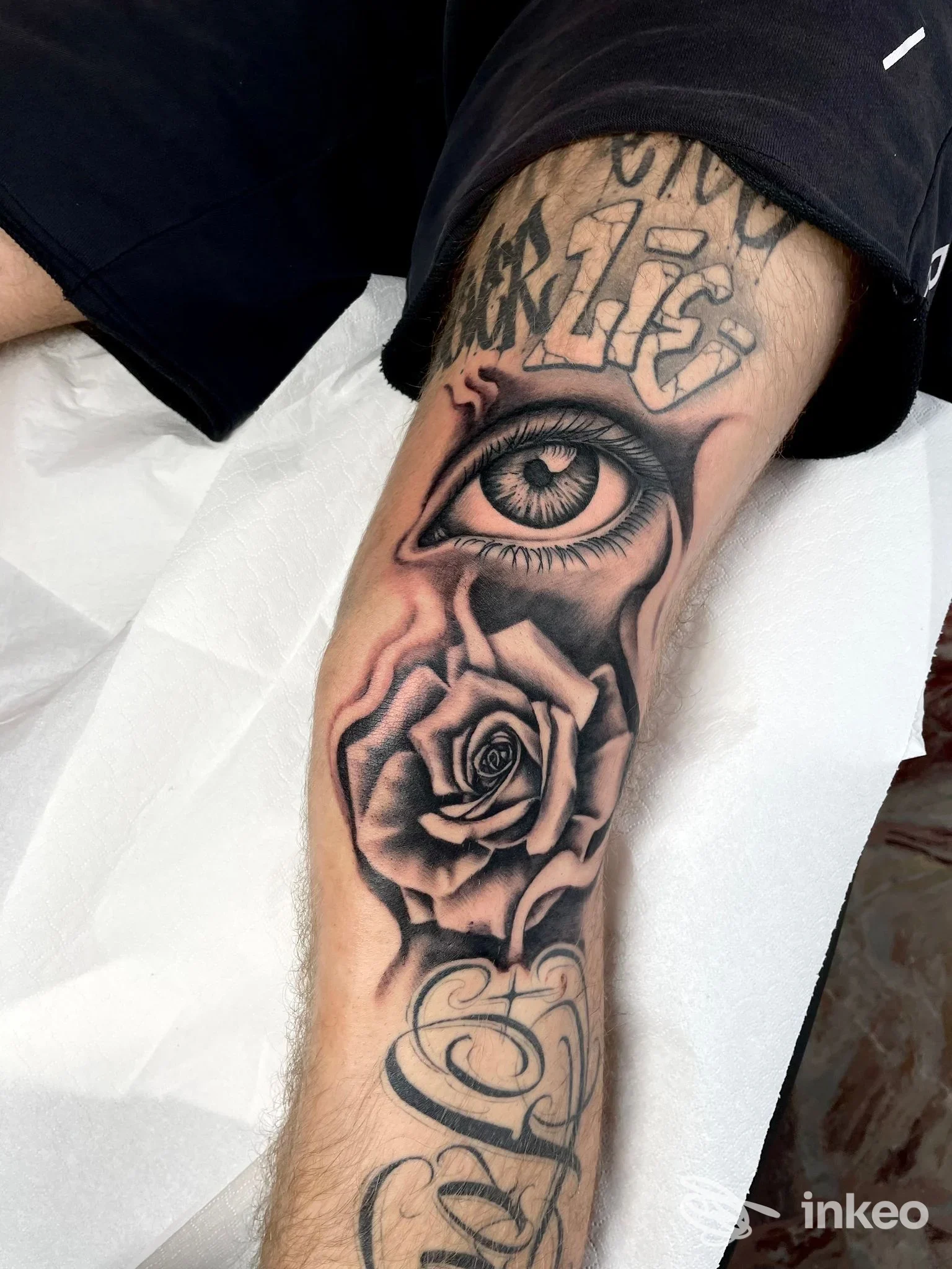 Avambraccio tatuato con occhio realistico e rosa in bianco e nero, foto fornita da All Ink Tatoo ad Alessandria.