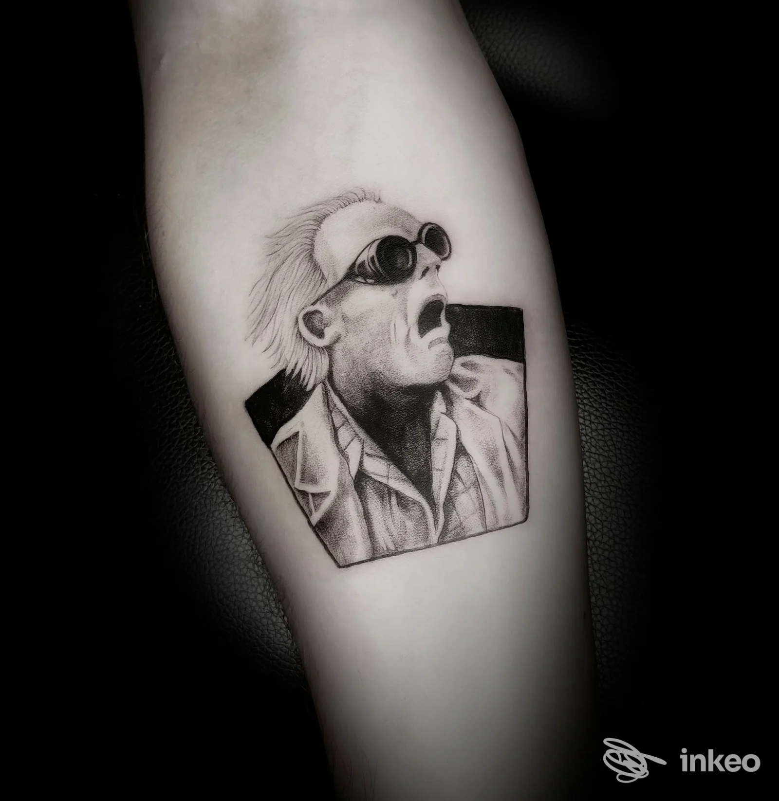 Tatuaggio realistico in bianco e nero su avambraccio raffigurante un ritratto con occhiali. ZerØtto Tattoo, Carpi.