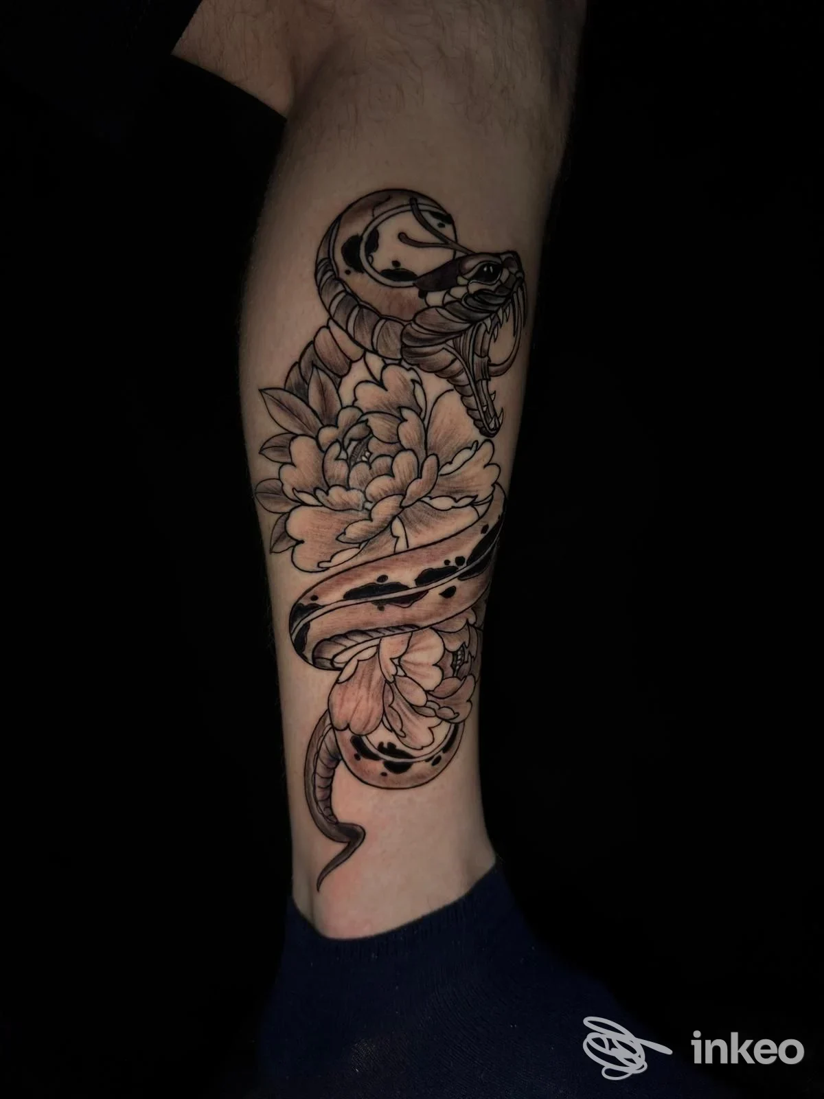 Tatuaggio su avambraccio con serpente avvolto e peonie, fotografia di Esse27tattoo ad Anagni.