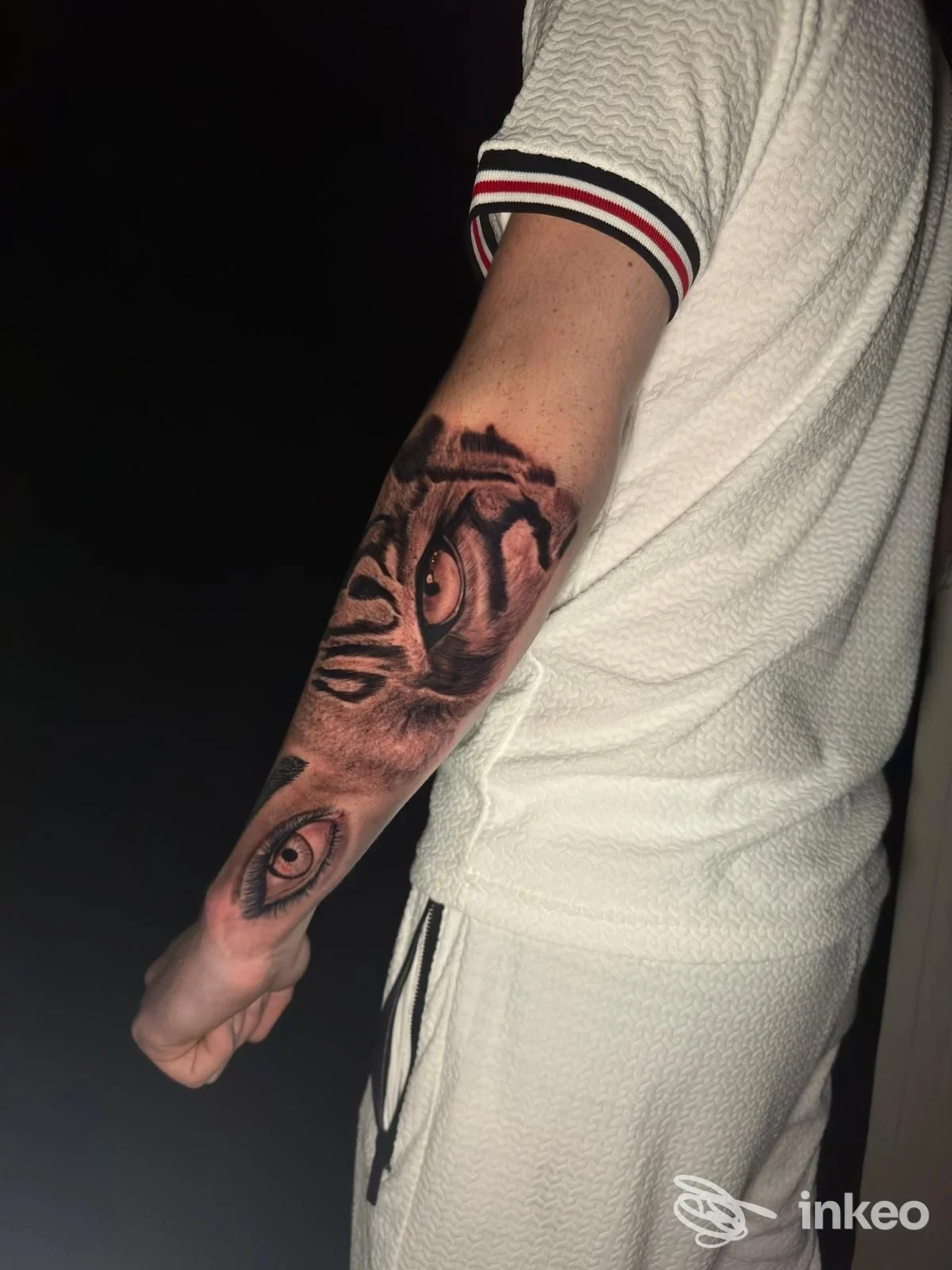 Fotografia dell'avambraccio tatuato con ritratto realistico e occhi dettagliati, scatto verticale per portfolio di Esse27tattoo ad Anagni.