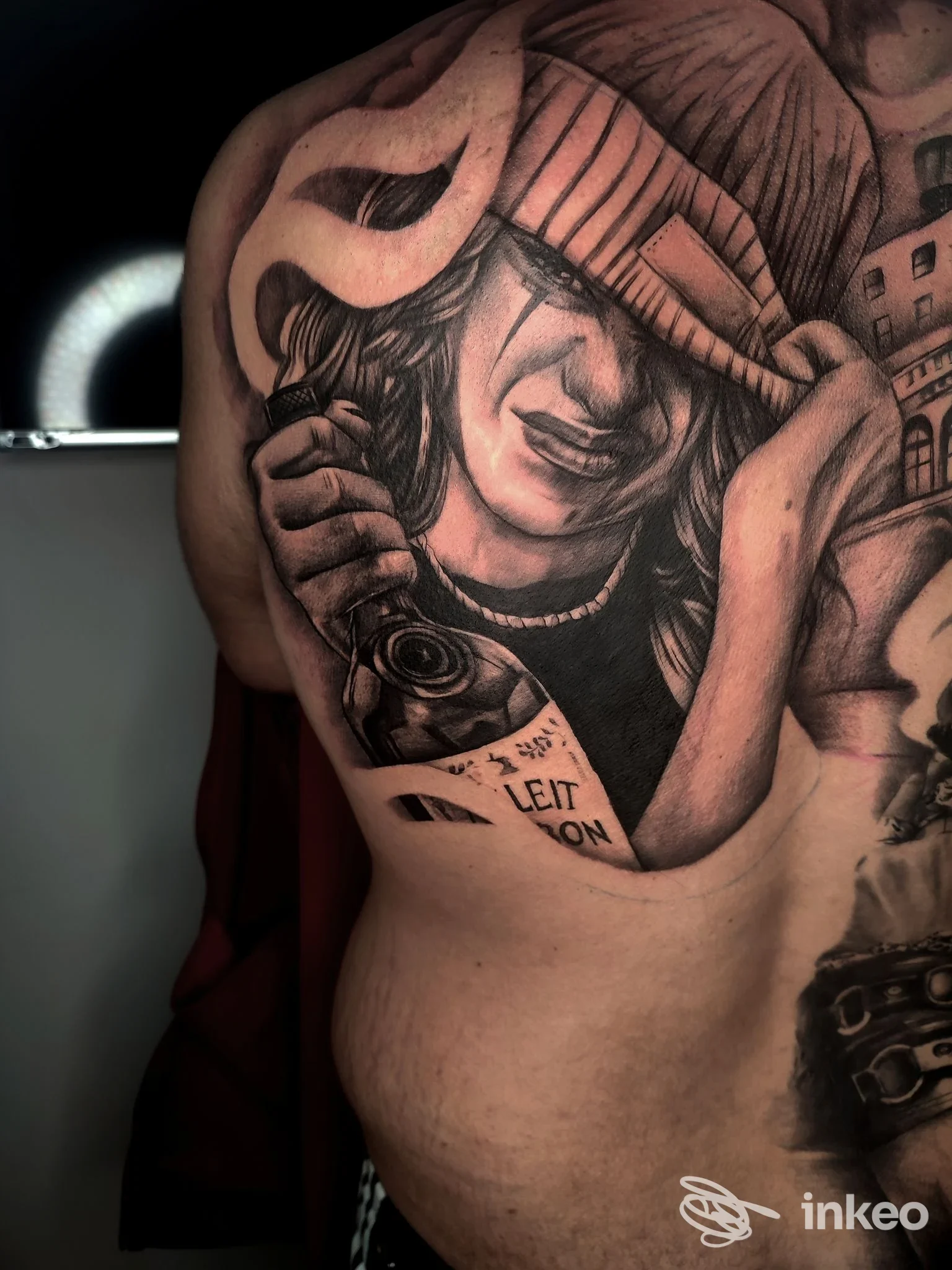 Grande tatuaggio in bianco e nero sul lato del torace/schiena, ritratto con cuffia e bottiglia. Black Angel tattoo, Fasano.