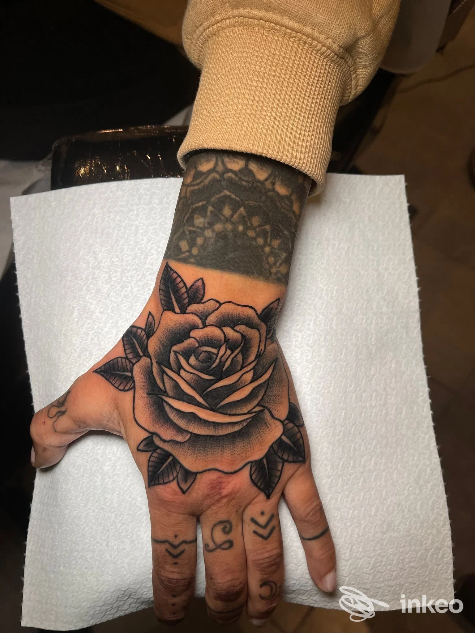 Tatuaggio a rosa in bianco e nero sul dorso della mano, con dettagli ombreggiati; realizzato da Shades Of Ink a Venezia.