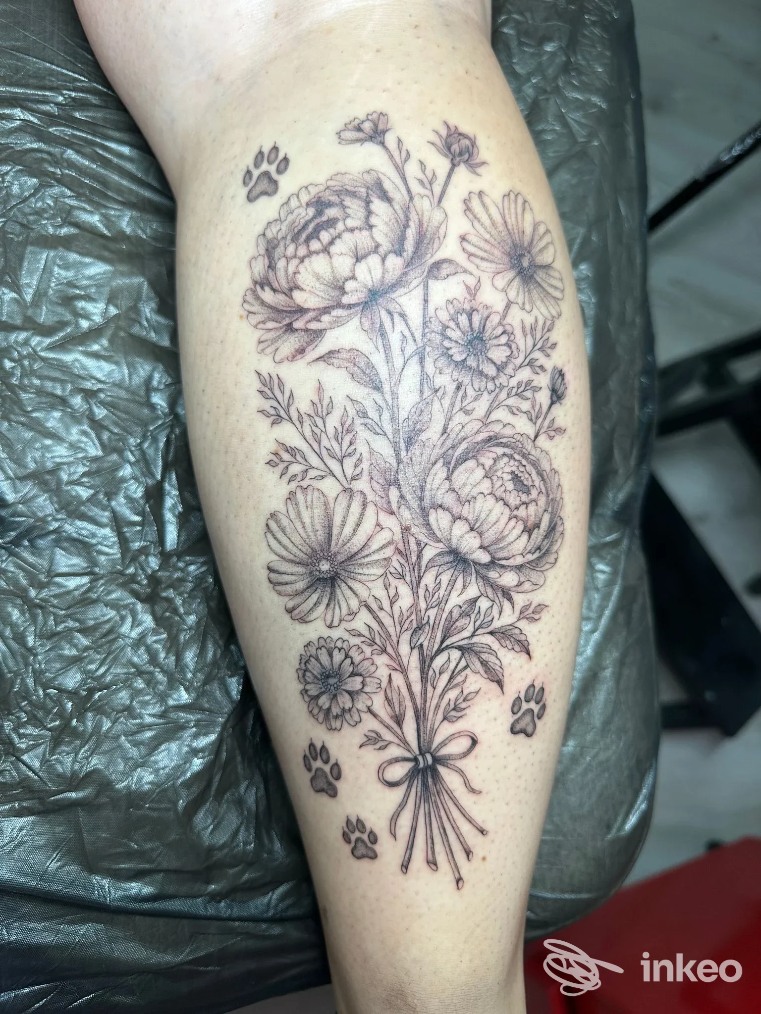 Tatuaggio a mazzo di fiori in bianco e nero sul polpaccio, realizzato da Make a Wish Tattoo Studio a Caorle.