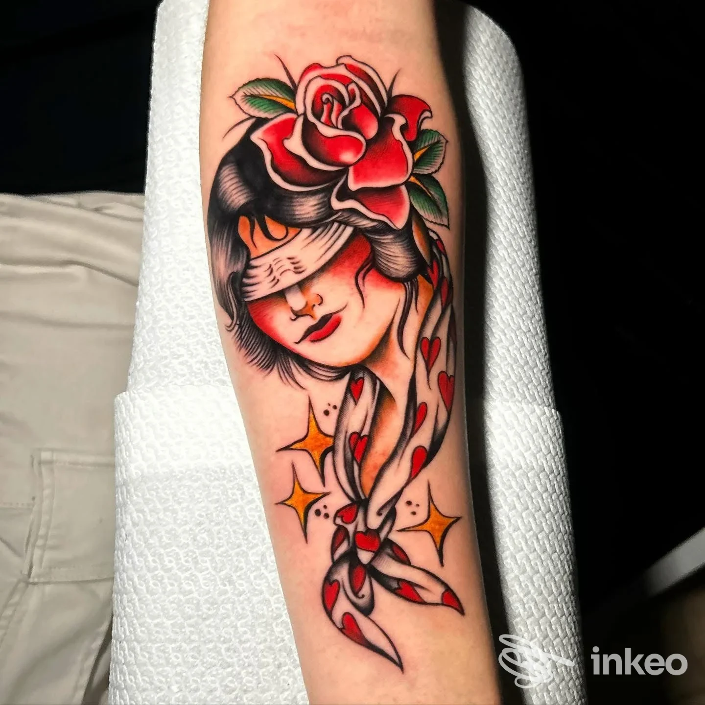 Tatuaggio tradizionale su avambraccio con volto bendato e rosa, UNDERSKIN-TATTOO STUDIO, Orta Nova.