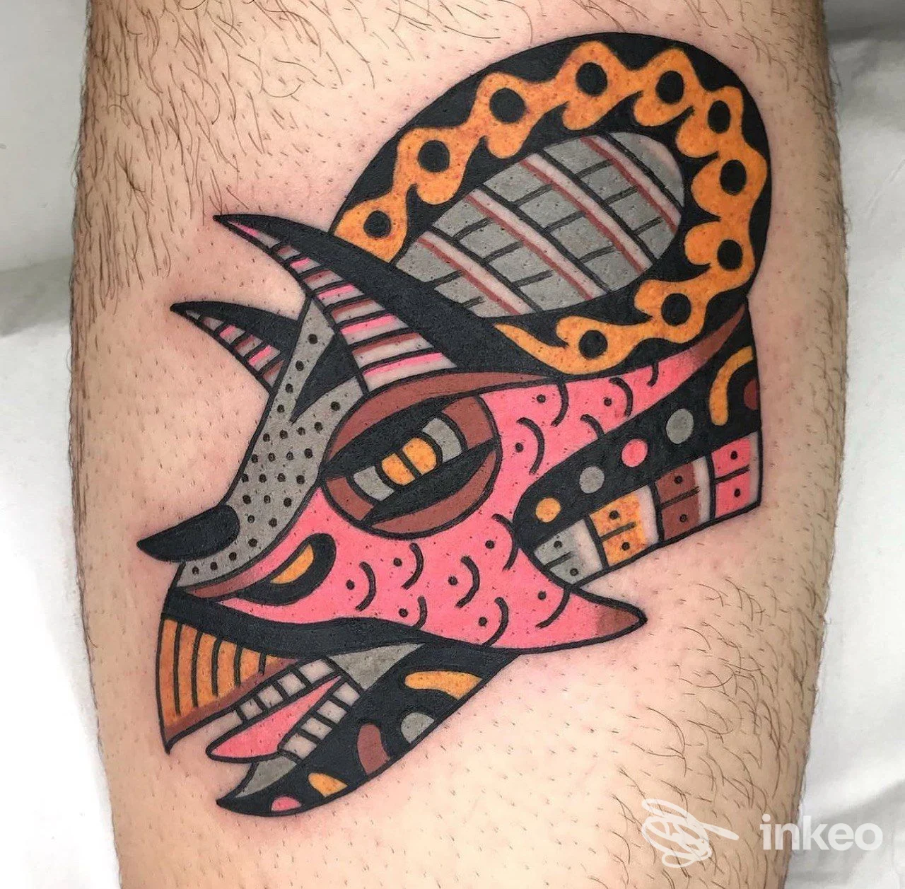 Tatuaggio neo-traditional a colori raffigurante una maschera stilizzata sul polpaccio, foto inviata da The Ink Harbor, Dolo.