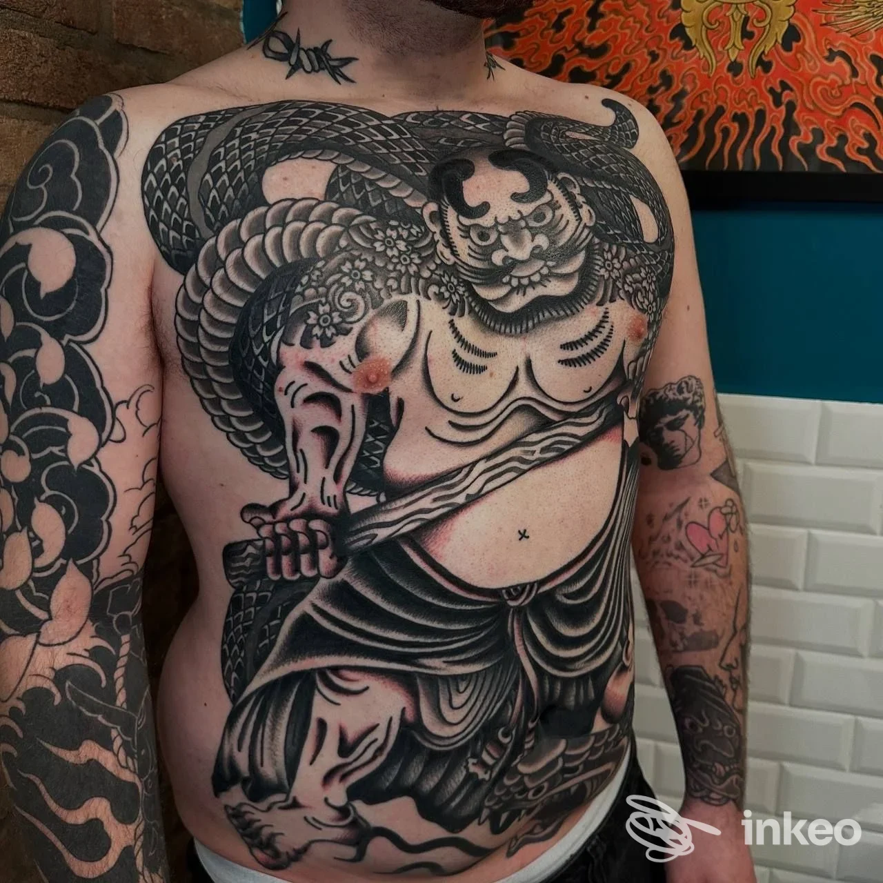 Ampio tatuaggio su torace e addome su cliente dello studio The Ink Harbor a Dolo, dettagli neri e ombreggiature intense.