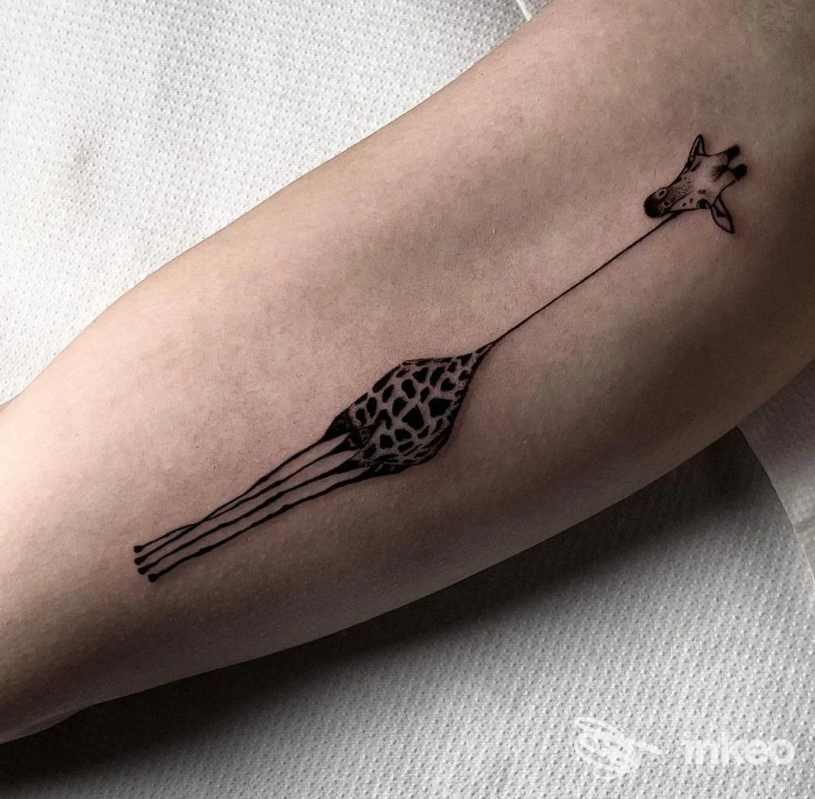 Tatuaggio di una giraffa stilizzata in nero sull'avambraccio, foto inviata da Vento Tattoo Studio a Bari.