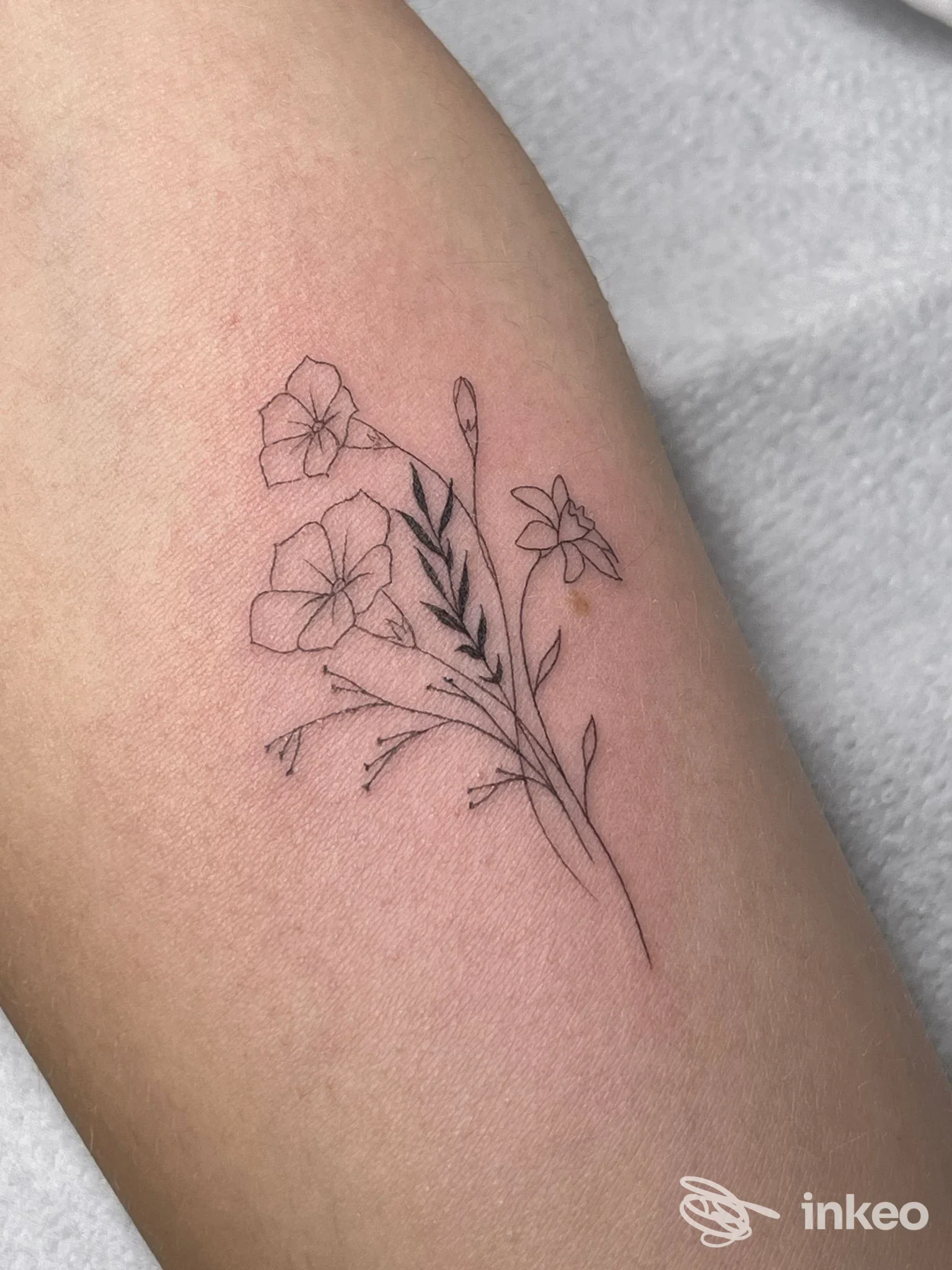 Sottile tatuaggio floreale linework sull'avambraccio, realizzato da AMA.TE Tattoo Studio a Villafranca di Verona.